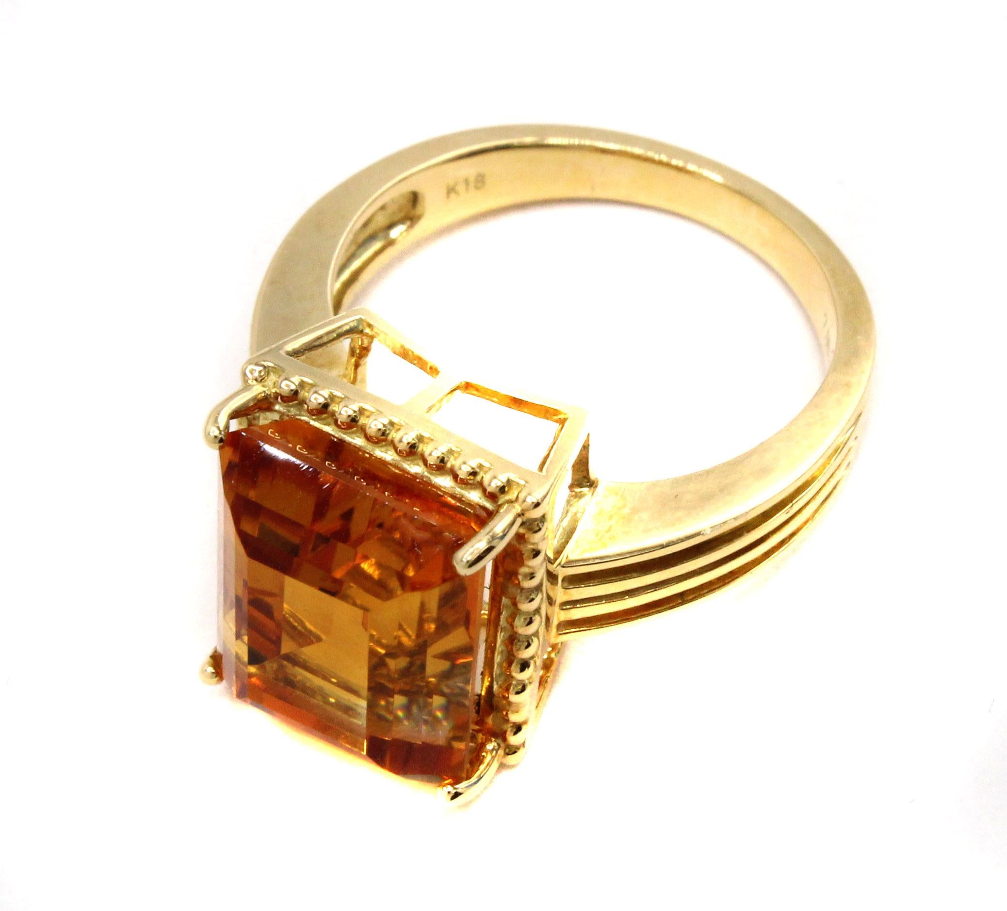Beautifully designed and well handcrafted this stylish 1980s ring features a vibrant emerald cut Golden Citrine. The perfectly cut center gemstone has an amazing color saturation and is full of life and fire. Measured to weigh approximately 7