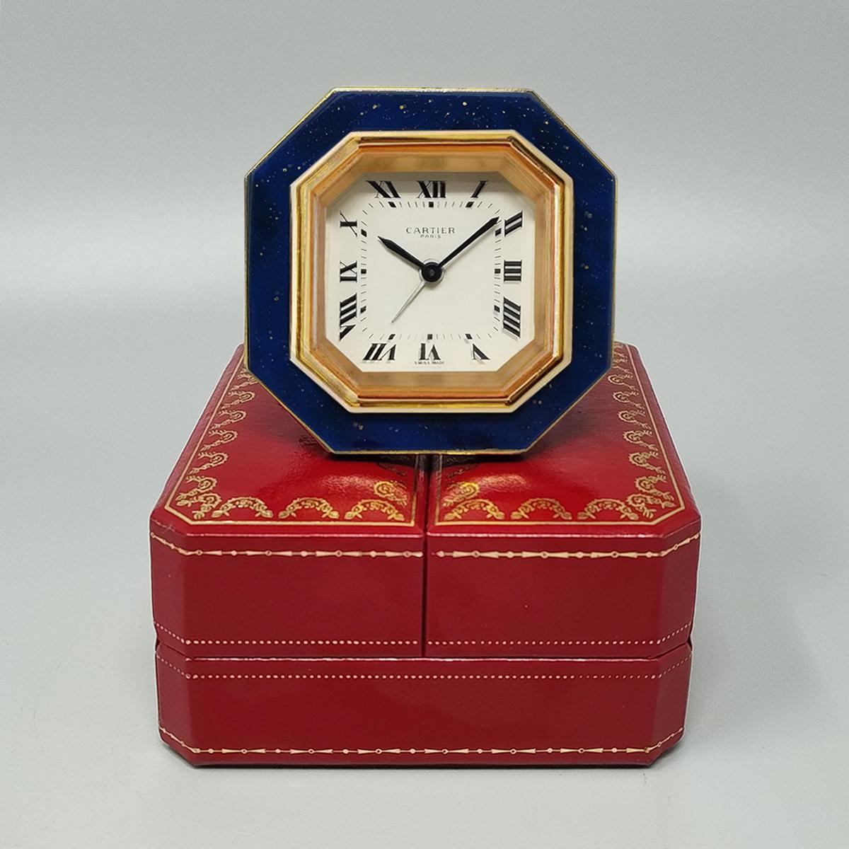 1980s Gorgeous Cartier alarm clock pendulette. Made in Swiss.
It's lapis lazuli and golden metal with manual winding. Clock case numbered 7507 10267. With original case, lined with red leather and with instructions. It works perfeclty and is in