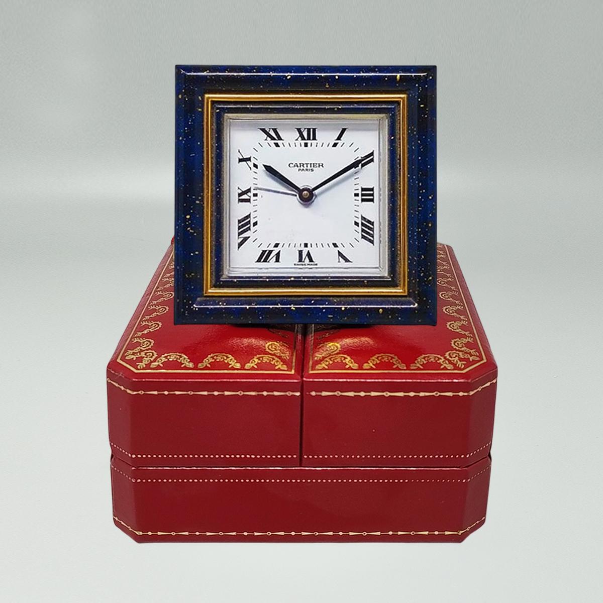 1980s Gorgeous Cartier alarm clock pendulette. Made in Swiss.
It's lapis lazuli and golden metal with manual winding. Clock case numbered 7503 07516. With original case, lined with red leather and with instructions. It works perfeclty and is in