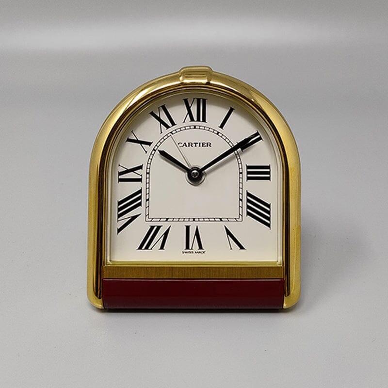 Magnifique pendulette réveil Cartier Romane des années 1980. Fabriqué en Suisse. Il est en or plaqué 18K. Cadran en émail blanc. Boîtier d'horloge numéroté 00523. Avec étui, doublé de cuir rouge et avec certificat. Il fonctionne parfaitement et est