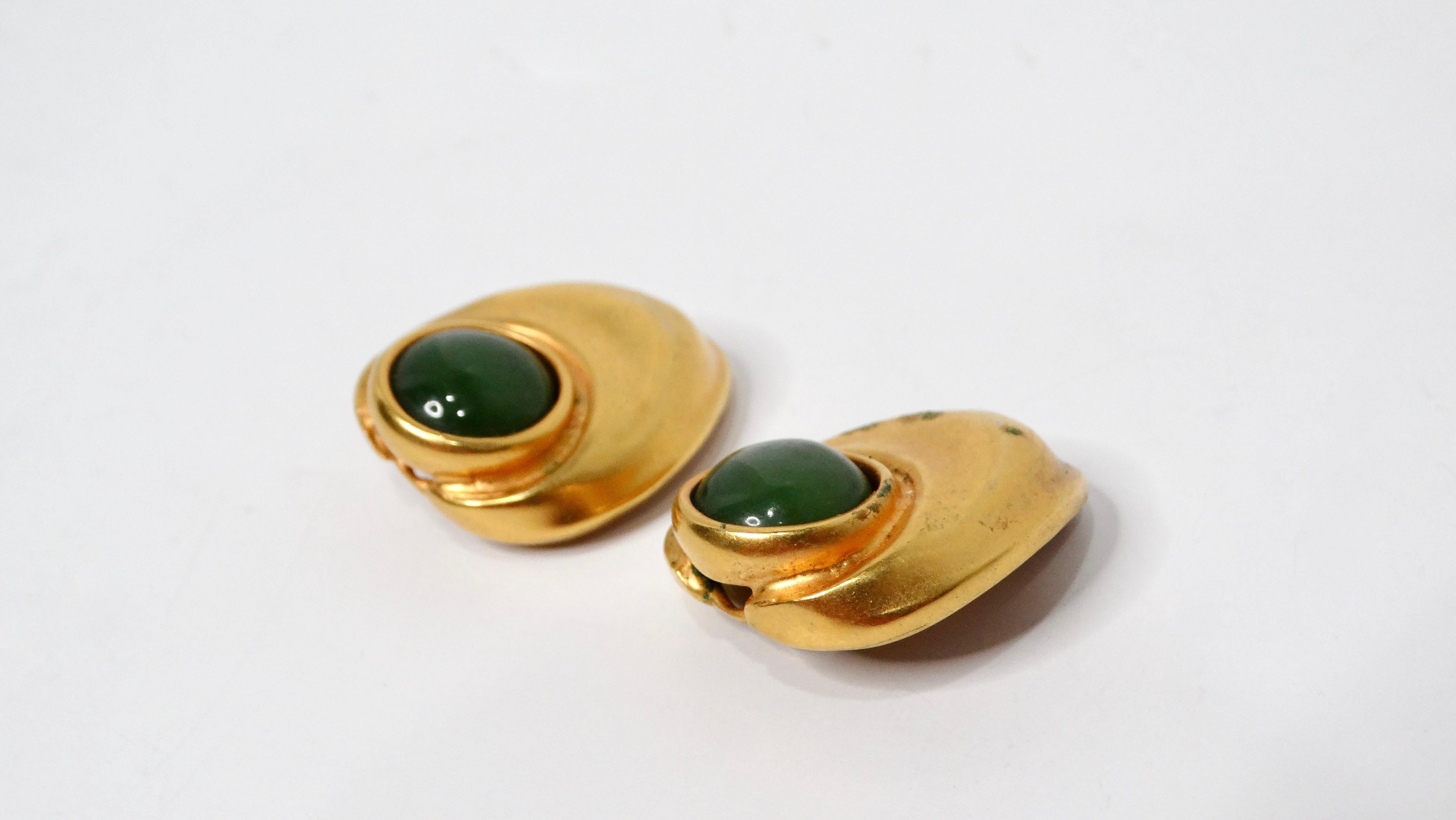 Discover the timeless elegance of these 1980s Green Cabochon Gold Tone Clip-On Earrings, a stunning accessory that effortlessly elevates any outfit. Featuring a rich green cabochon nestled at the center, these earrings are set in a warm gold tone
