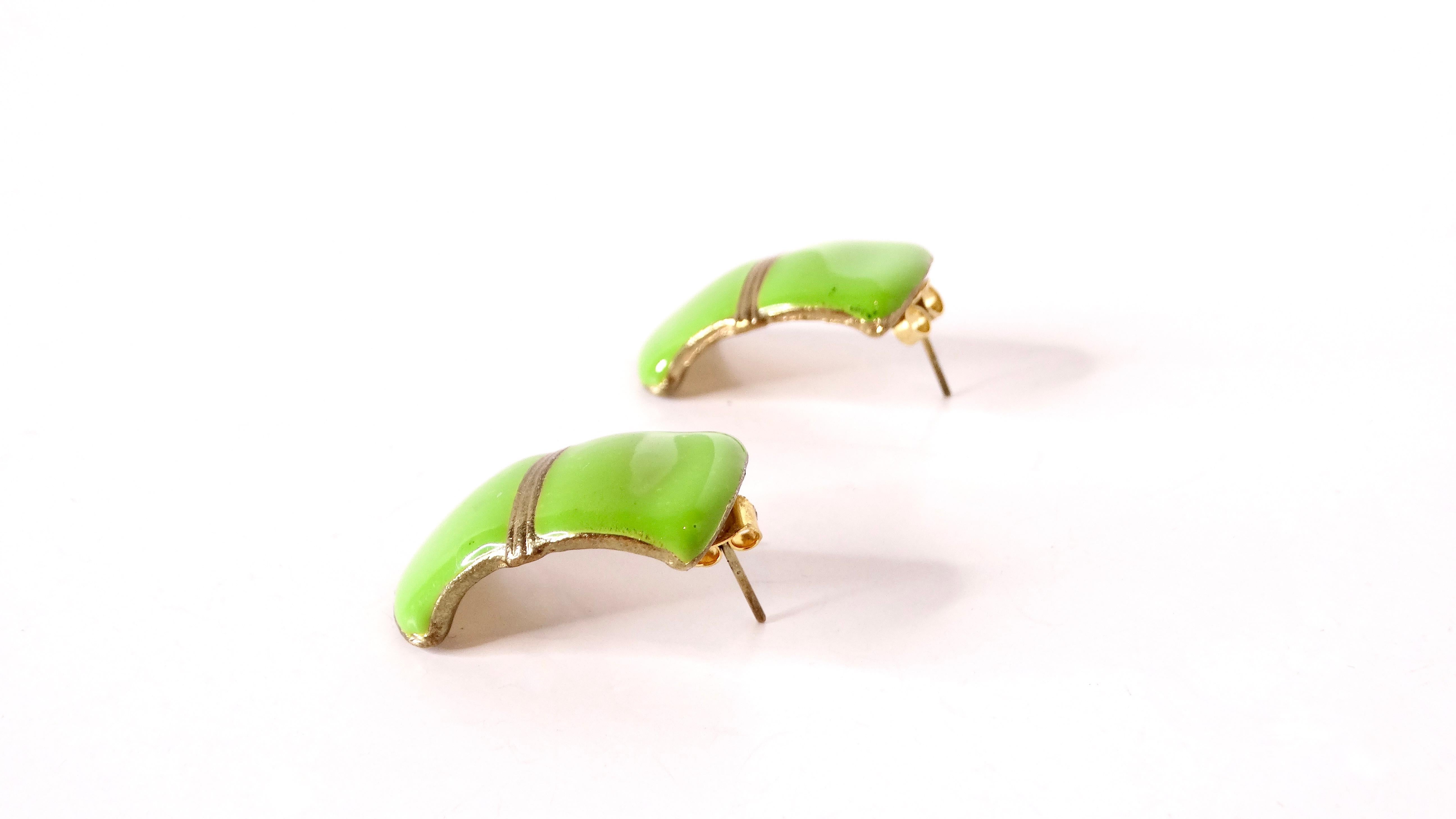 These exquisite Circa 1980s Green Enamel 14k Gold Plated Curved Earrings are a stunning accessory that captures the essence of vintage elegance. Featuring a beautiful green enamel coating on a curved design, these earrings shimmer gracefully,
