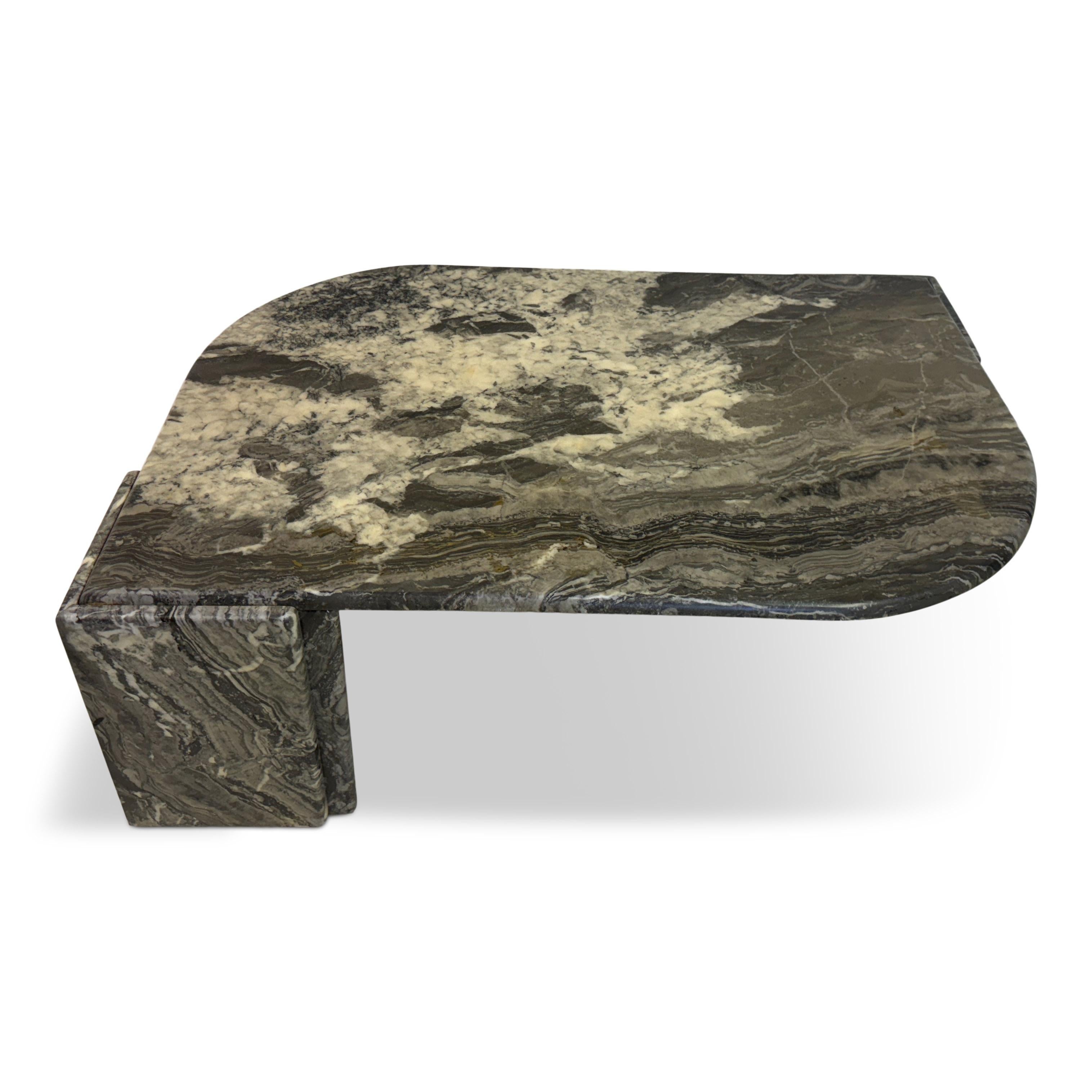 Mesa de centro de mármol gris de los años 80

La mesa tiene una característica forma de lágrima, con un extremo suavemente redondeado y el otro más anguloso. Esta forma única añade un toque contemporáneo y artístico a la pieza. La mesa está hecha de