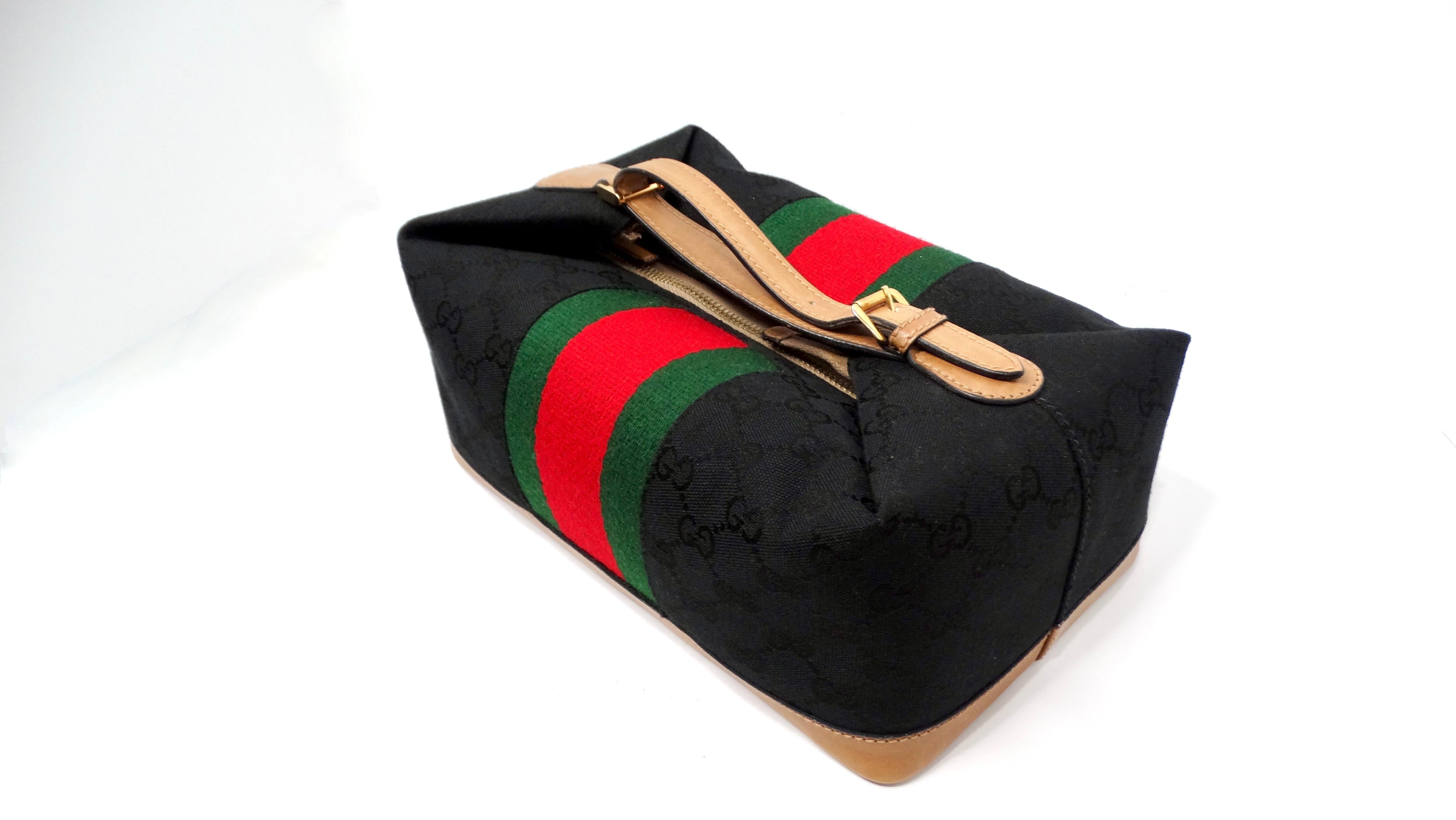 Step back in time with this exquisite 1980s Gucci Black GG Monogram Canvas Boxy Vanity Bag.  Its iconic black GG monogram canvas base is beautifully contrasted by the signature red and green Gucci stripe motif centered on the bag. A complementary