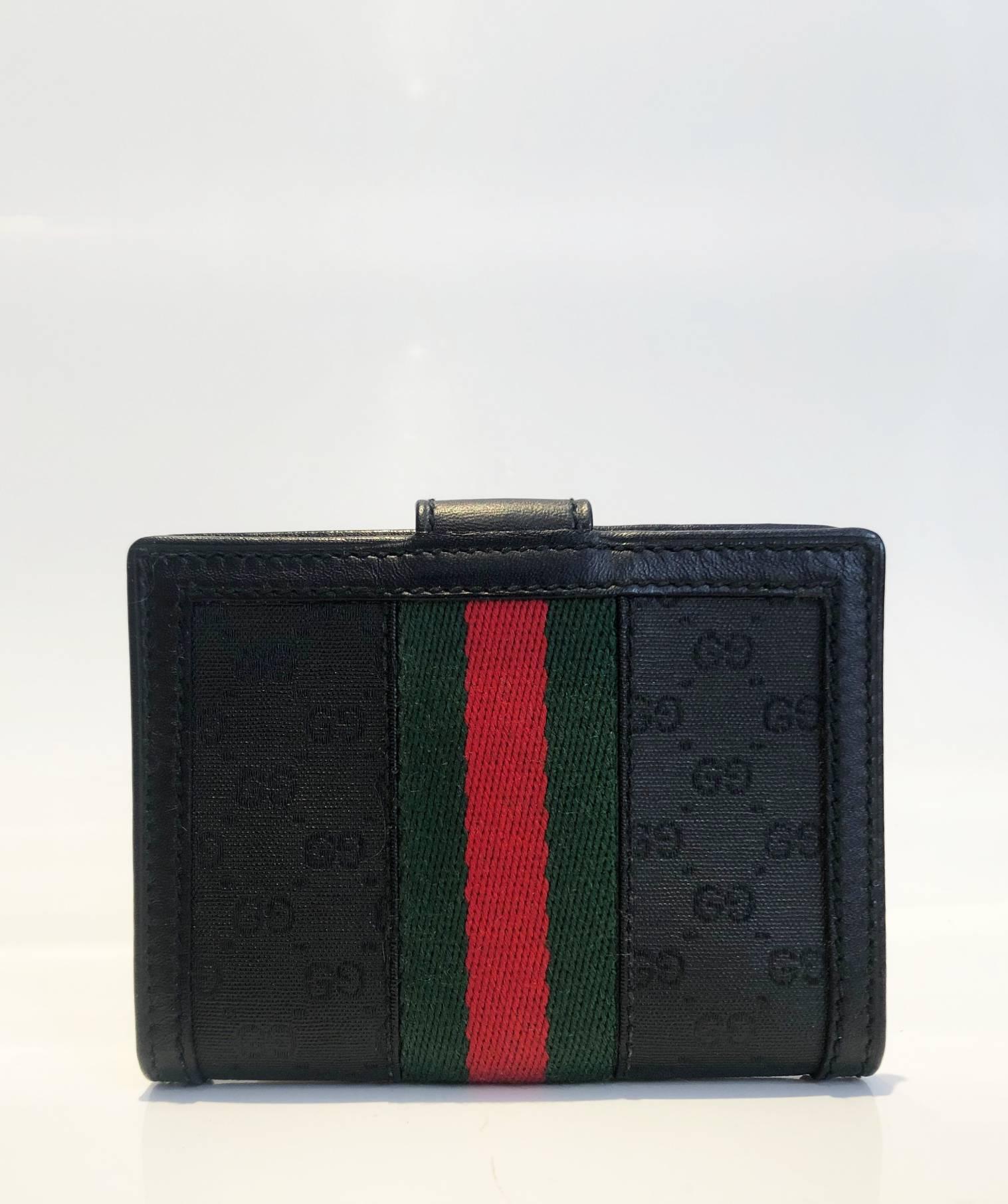 Gucci black web card holder featuring black monogram cloth and black leather, GG gold tone metal frontal logo, inside Gucci metal plaque, 2 internal compartment and plastic folder for cards, Made in Italy  

 Dimensions: 9x7x2cm 
Condition: 1980s,
