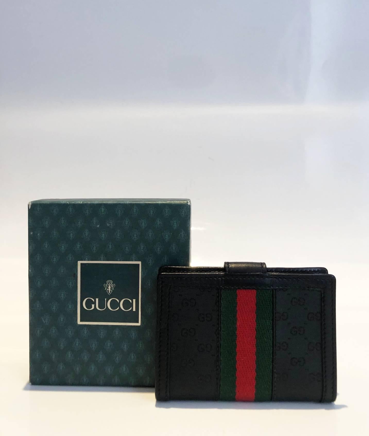 Gucci black web card holder featuring black monogram cloth and black leather, GG gold tone metal frontal logo, inside Gucci metal plaque, 2 internal compartment and plastic folder for cards, Made in Italy  

 Dimensions: 9x7x2cm 
Condition: 1980s,