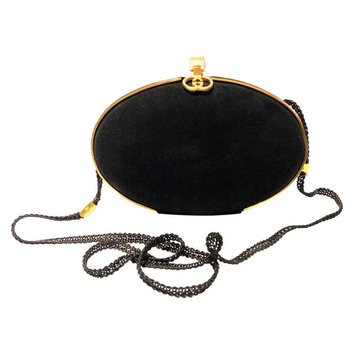 Gucci Black Vintage Gold Clutch Bag, black suede hard shell oval rounded clutch bag, Gold edge trim and GG logo and clip clasp at top. Inside, classic GG printed fabric with small card pocket and popper string shoulder strap with logo details;