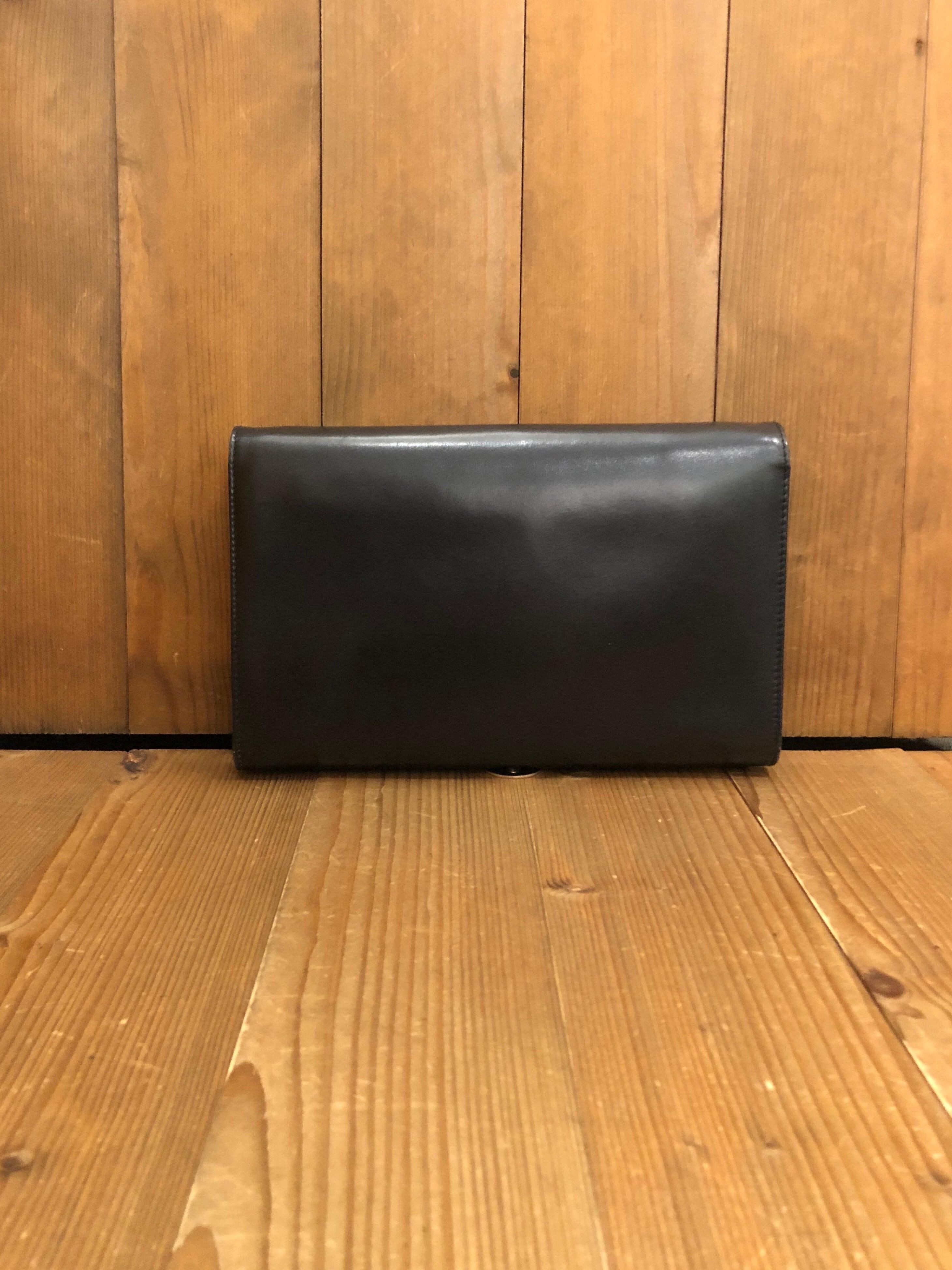1989s Gucci two way clutch shoulder bag in black leather featuring a leather trimmed GG buckle closure. Made in Italy. Measures 9.75 x 6 x 1 inches with two main compartments and one interior zip pocket. Comes with replacement chain. 

Condition -