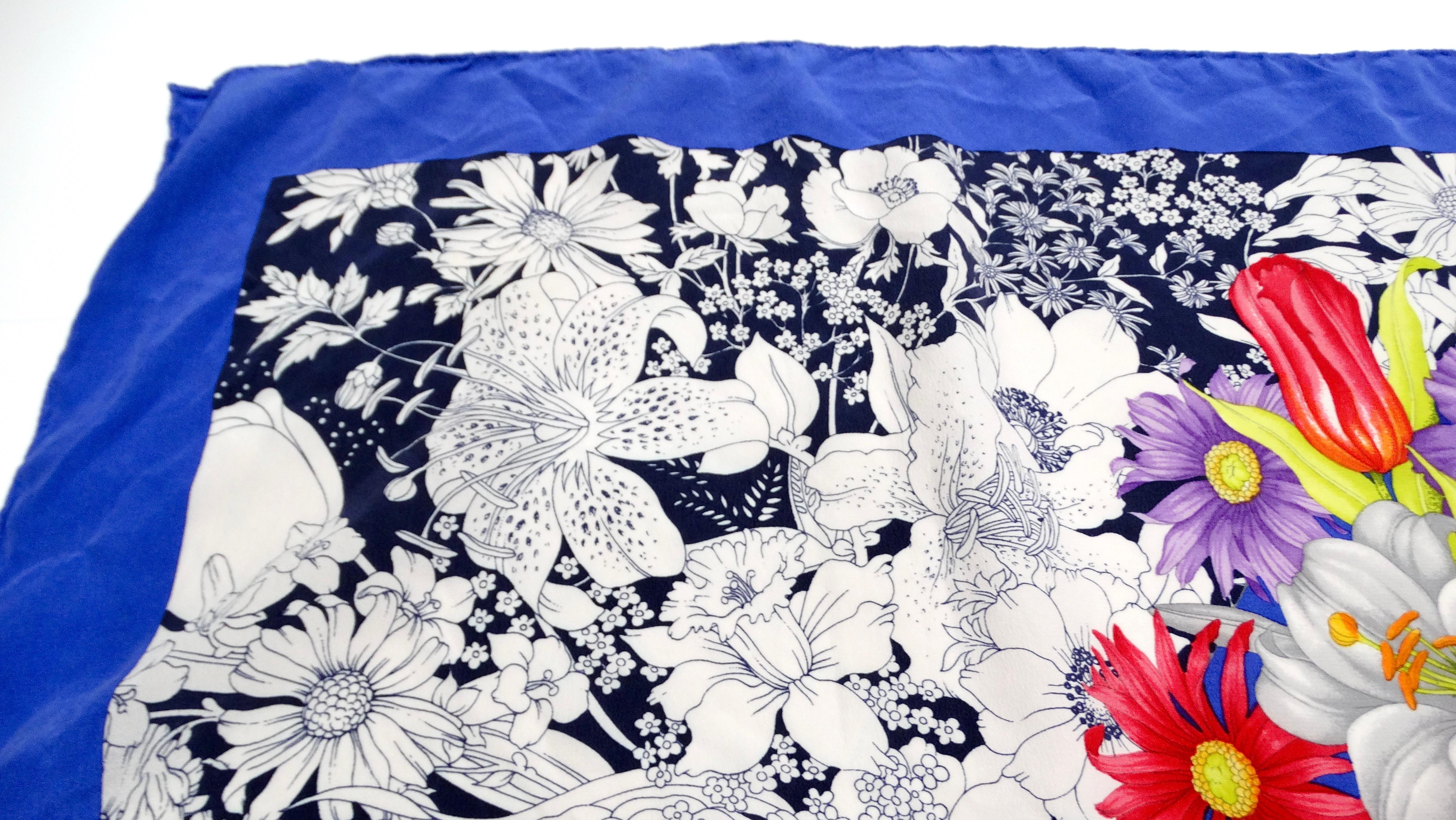 The exquisite 1980s Gucci Blue Flower Bouquet Print Silk Scarf is a stunning piece that embodies the elegance and artful flair of vintage luxury. This scarf features a captivating bouquet of flowers in vibrant hues, skillfully set against a backdrop