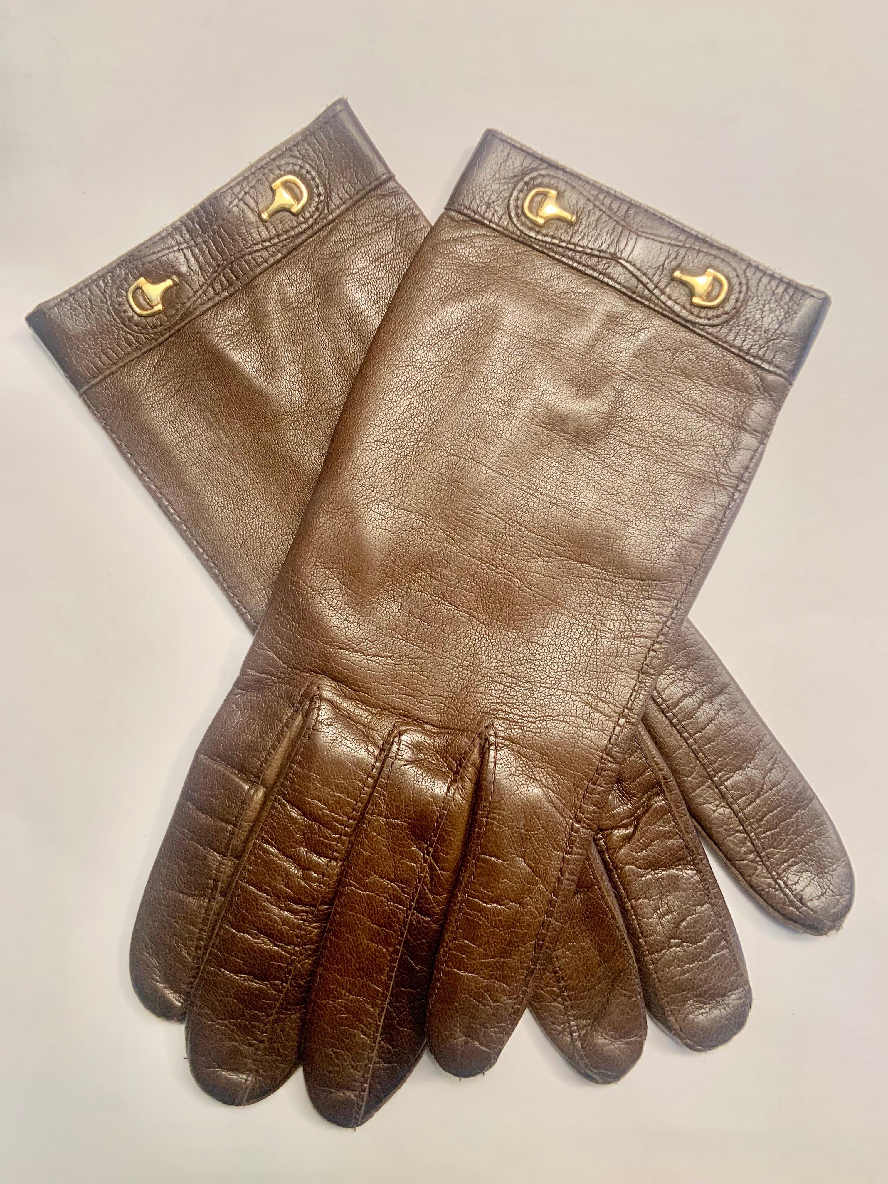 Never worn, these Gucci chocolate brown leather gloves are in excellent condition. They are trimmed at the wrist with a pair of gold toned horse bits, lined in brown silk and marked a size 6 1/2 which is a Small. 
Very often your glove size is the