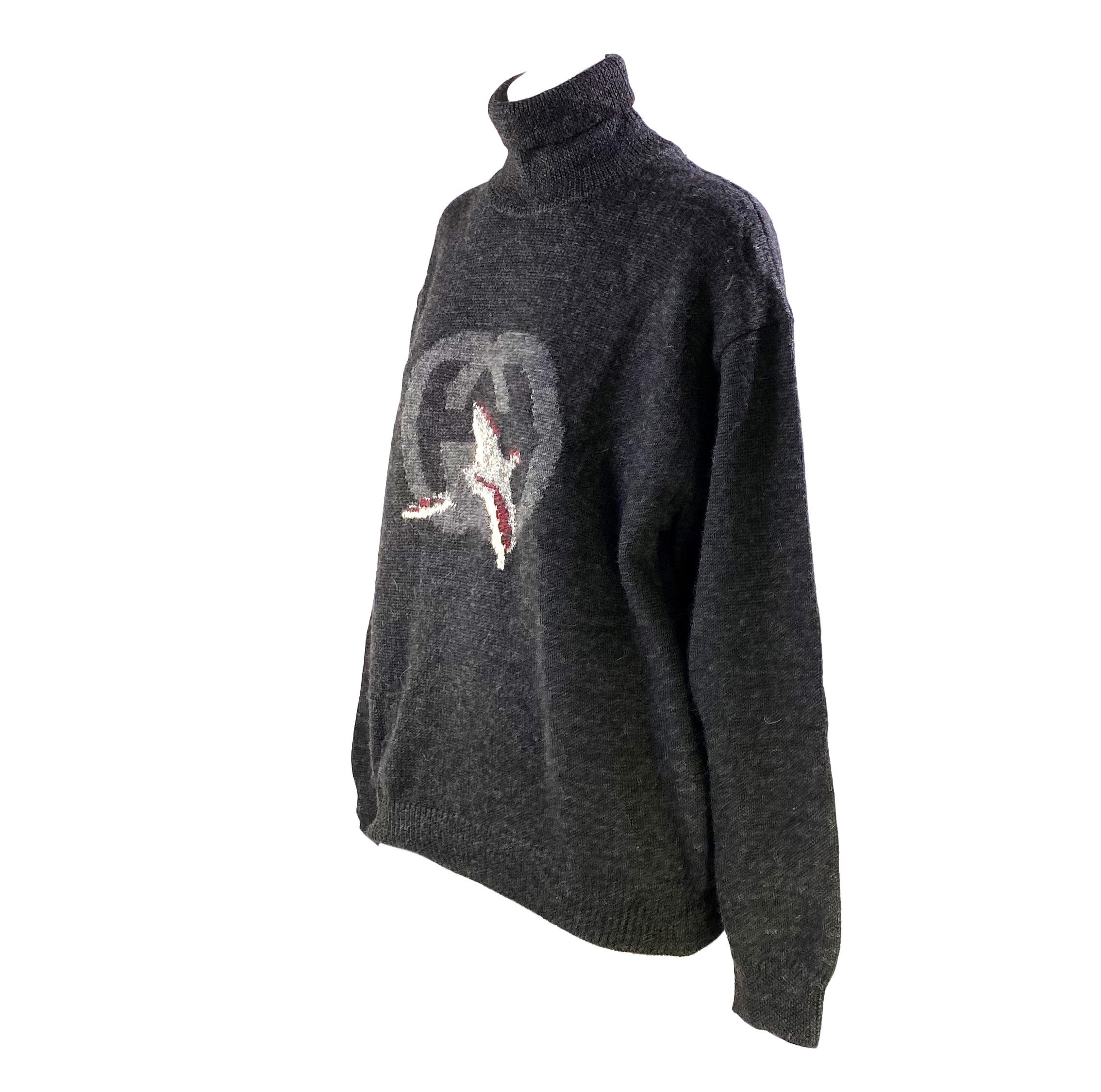 Presenting a rare oversized 'GG' logo wool and alpaca pullover turtleneck sweater designed by Gucci in the 1980s for their menswear line. The tonal logo is accented with an image of a pheasant-like bird as an homage to Gucci's sportswear DNA. This