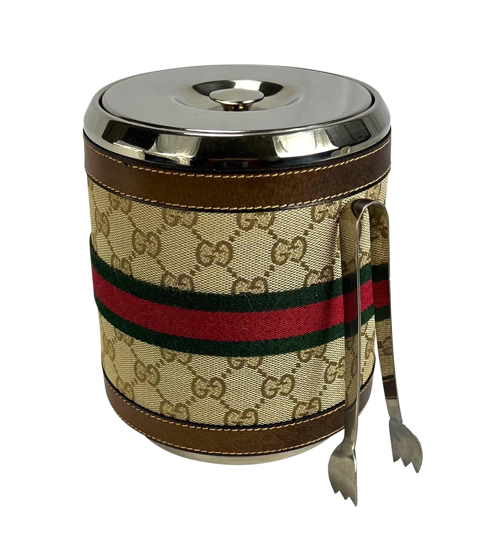 TheRealList presents: an incredible Gucci 'GG' monogram ice bucket. From the 1980s, this ice bucket is covered in brown leather and Gucci's iconic 'GG' monogram canvas. This fabulous ice bucket features stainless steel details and is made complete