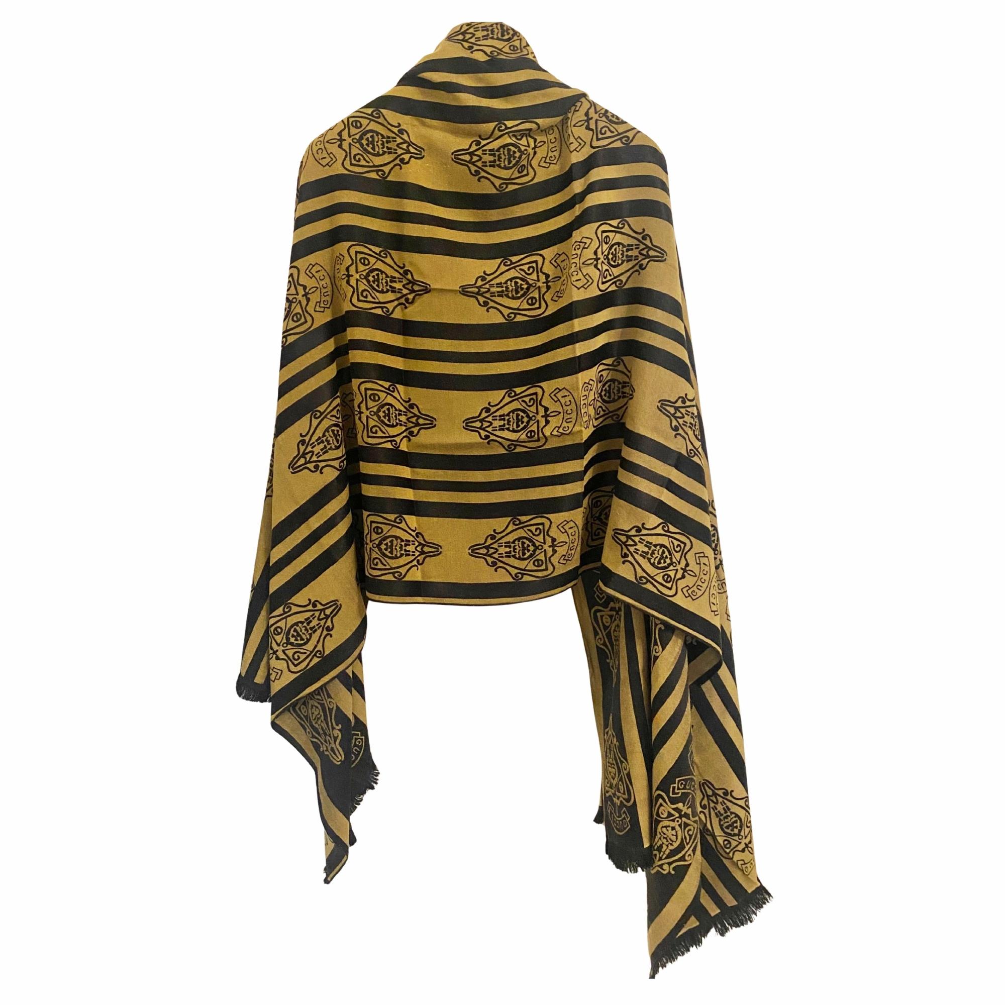 1980s Gucci wool scarf in black and gold, with a regimental stripe and logo crest repeat. It’s large-format and carries clear signs of Gucci’s transitional branding phase between traditional heritage and 1980s visual assertiveness, Made in