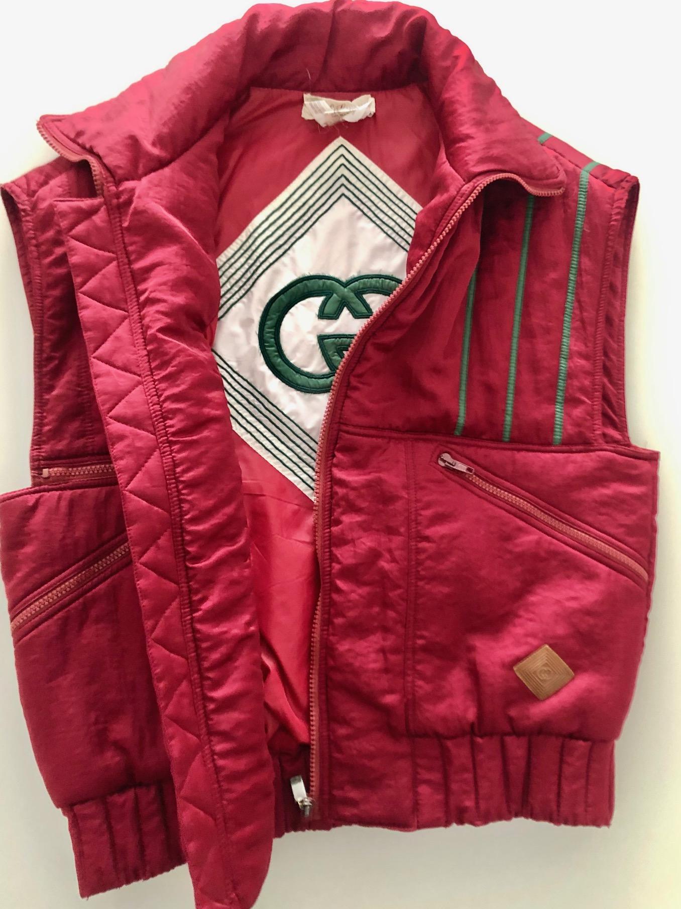 Vintage 1980's Gucci Fall/Winter puffer vest jacket t in pink, green frontal stripe details, 3 frontal zipped pockets, high collar, front zip, inside Gucci green logo on white background, logo printed on leather, 100% polyester, Made in