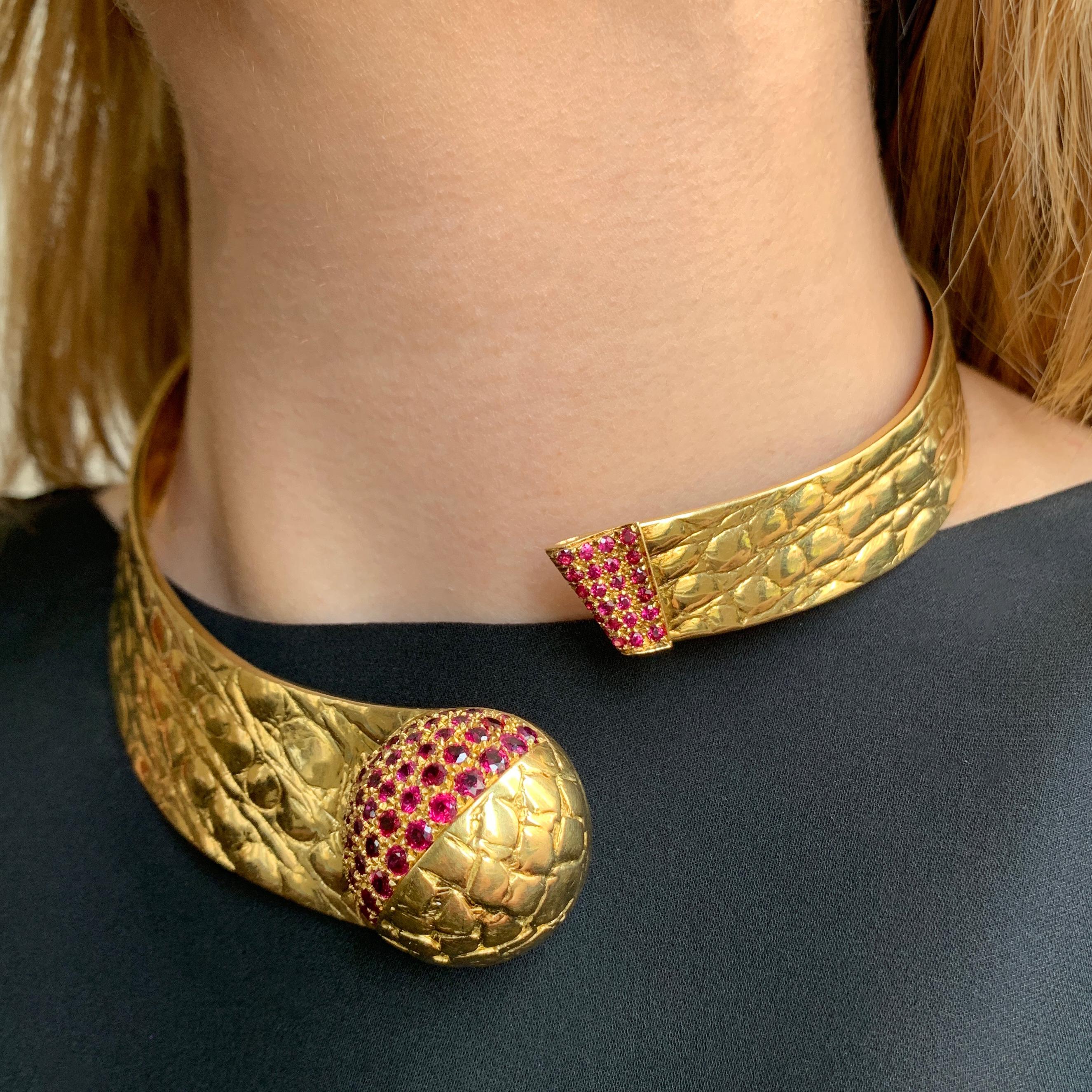 An 18 karat textured gold and ruby hinged collar, by Gucci,  1980s.

Stamped Gucci, 750 with Italian hallmarks. The necklace measures 17