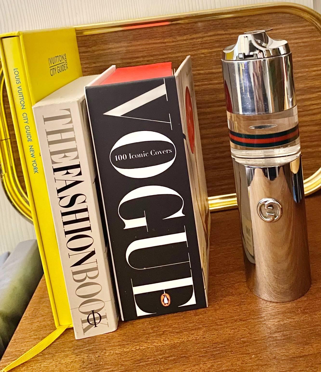 A rare vintage 1980s Gucci Italian table lighter in Lucite acrylic and metal chrome, stamped Gucci Made in Italy on the base. It splits in the middle as a vacuum hidden space for cigarettes or whatever you wish tucked away. It releases with a twist