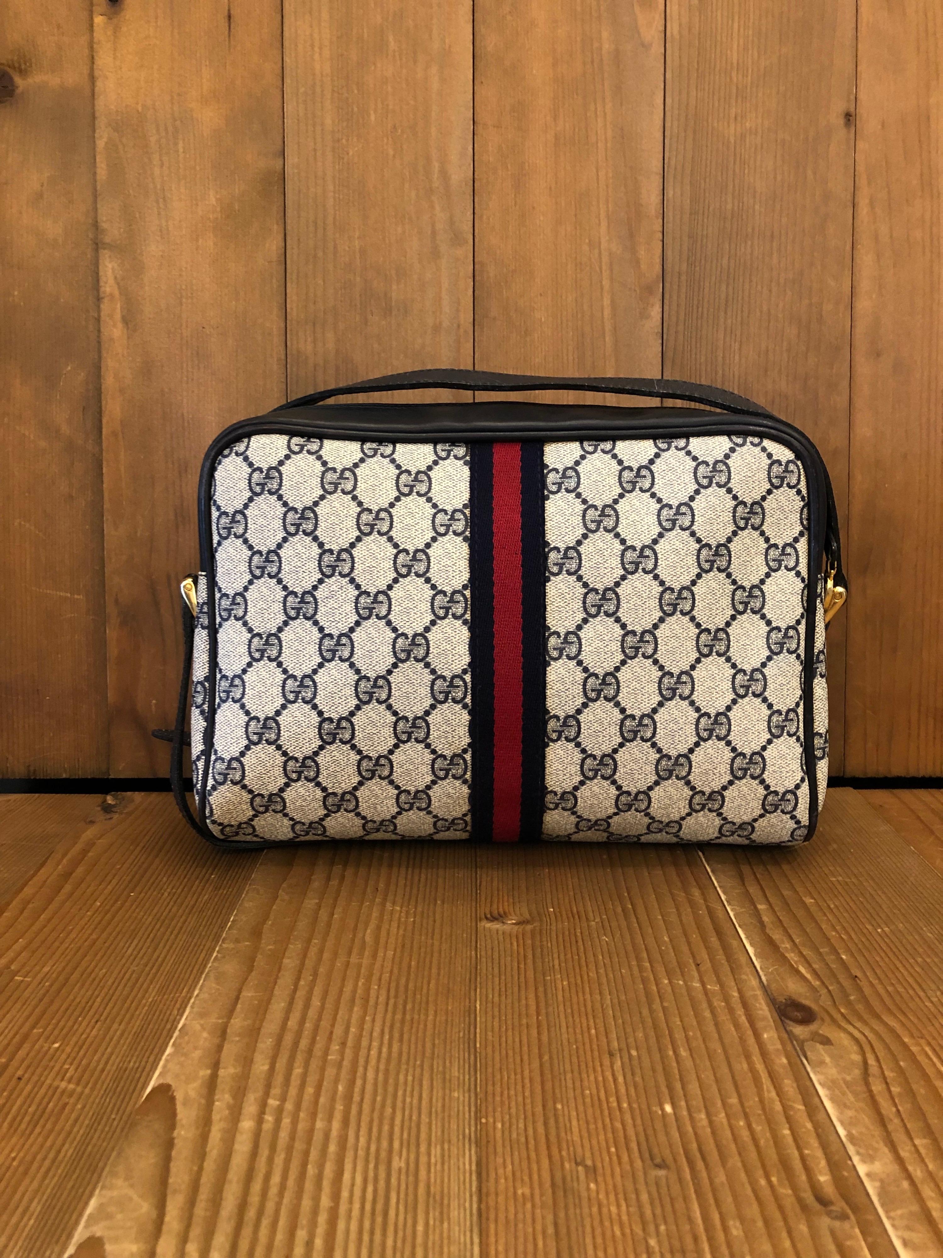 A vintage Gucci web crossbody bag from the 1980s in navy monogram canvas with iconic Gucci navy/red web featuring one front zip pocket and one interior zip pocket. Made in Italy. Measures approximately 10 x 7 x 3.5 inches Strap drop 19 inches.