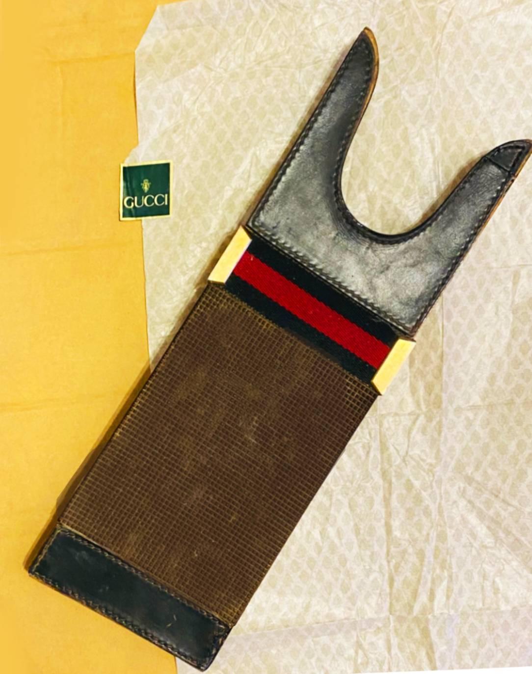 An exceptional piece from the very core of Gucci House, this boot jack is made of wood, featuring leather trim, original cloth leather stripe, gold tone metalware, navy blue rubber / reinforced, stamped Made in Italy by Gucci 

Condition: 1980s,