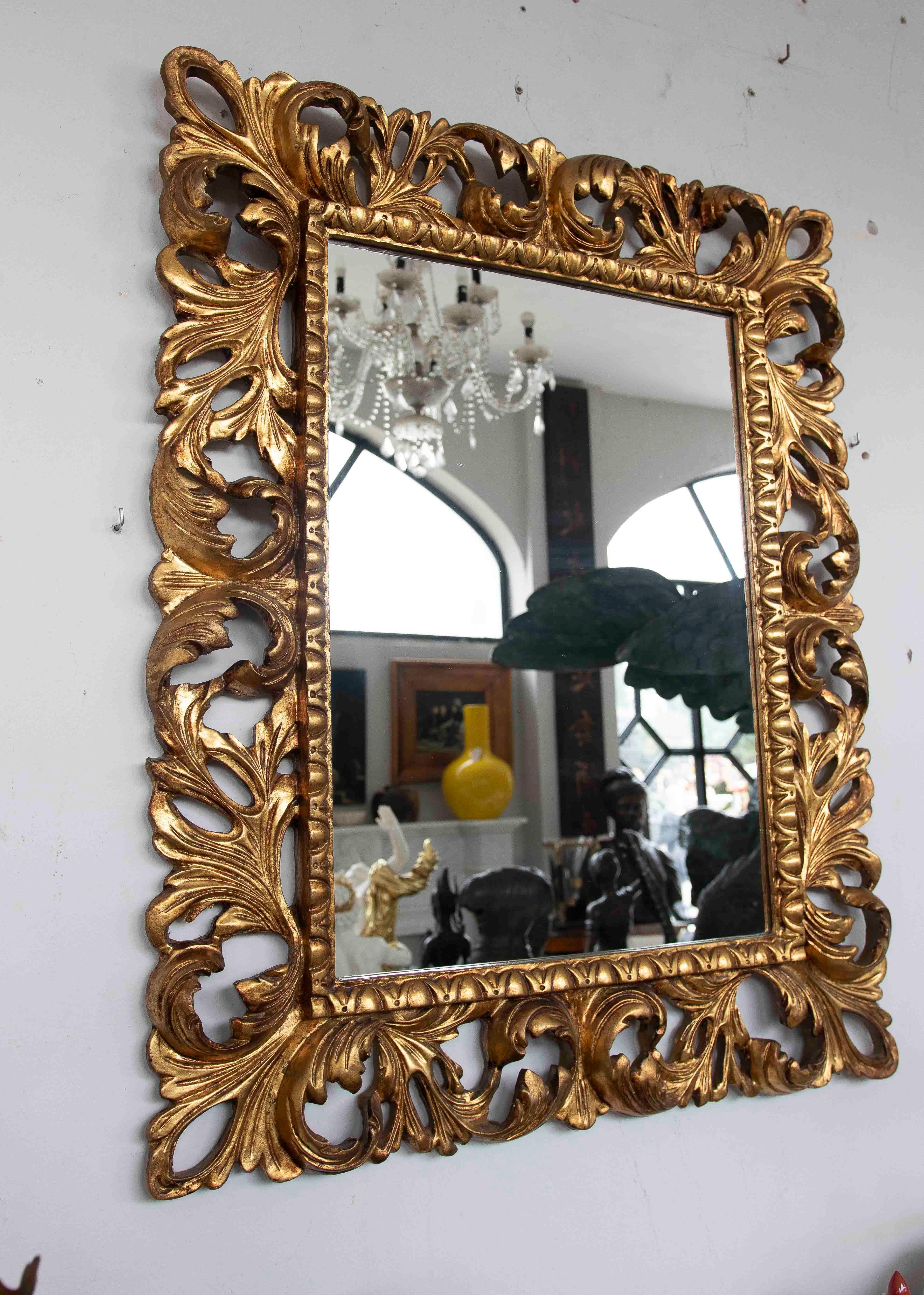 A stunning Baroque mirror with a hand-carved wooden frame and gold leaf finish. Its openwork ornamentation, inspired by acanthus leaves, lends elegance and movement to the piece. The aged gilding enhances its historical and artisanal character,