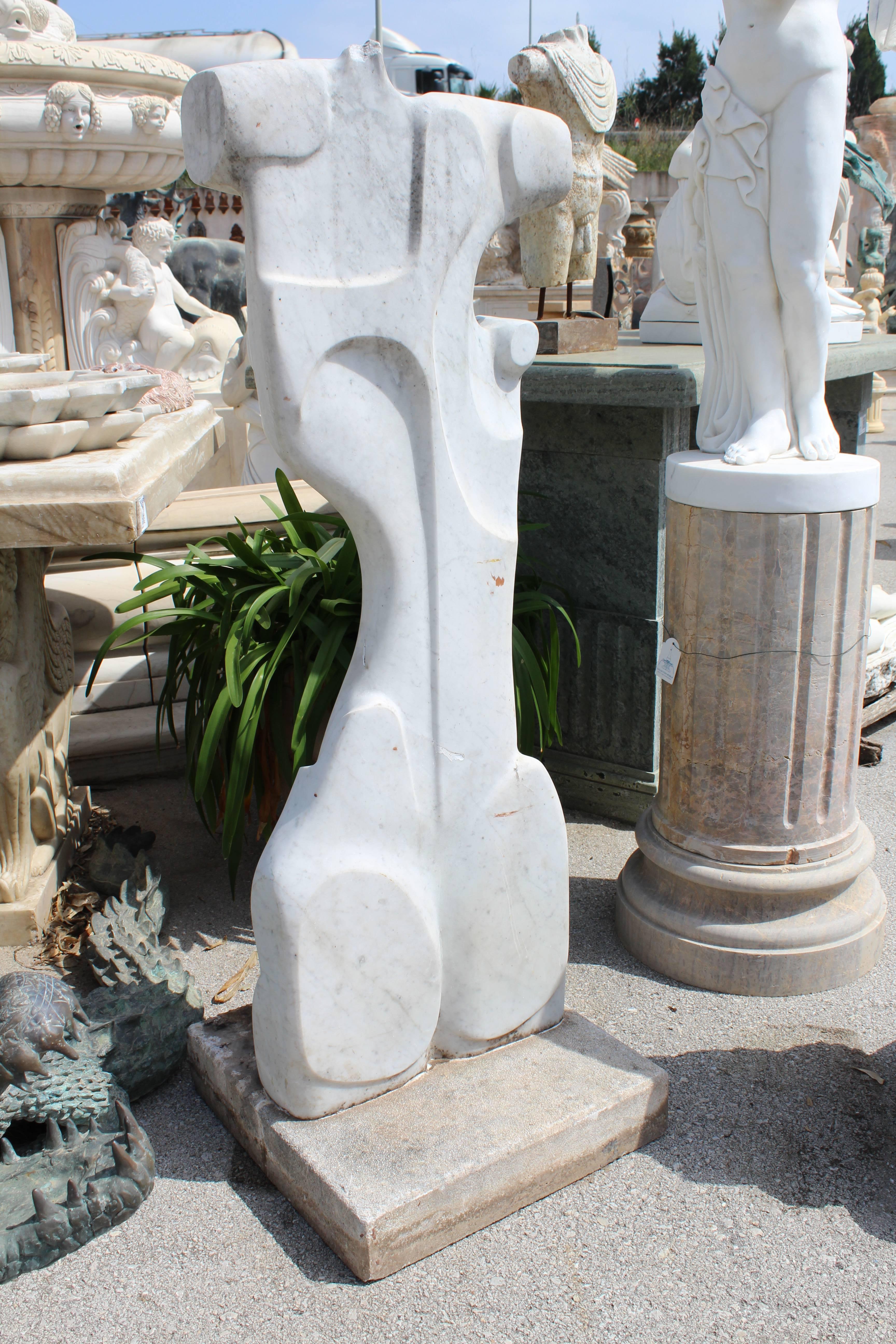 Modernist sculpture representing an abstract representation of the female body. Hand carved in white Carrara marble with a pedestal.