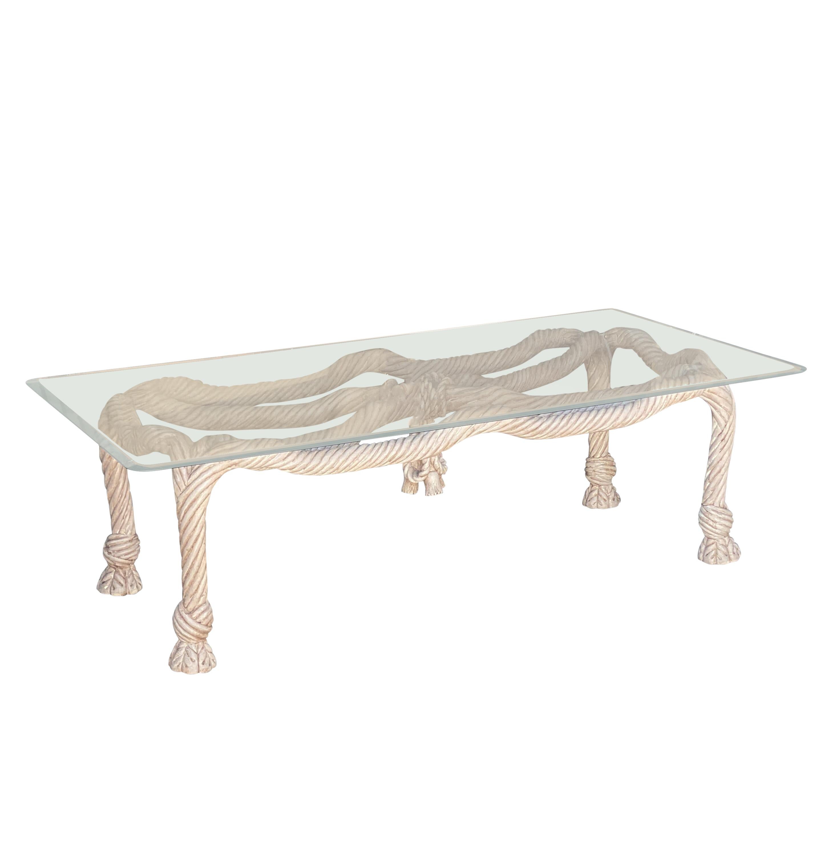 A vintage hand-carved rope wood coffee table in a limed or pickled wood finish. A simple glass top sits on top. Tasseled feet and carved wood. Overall in good condition, with minor hairline cracking to the wood for its age. From the 1980s. Glass top