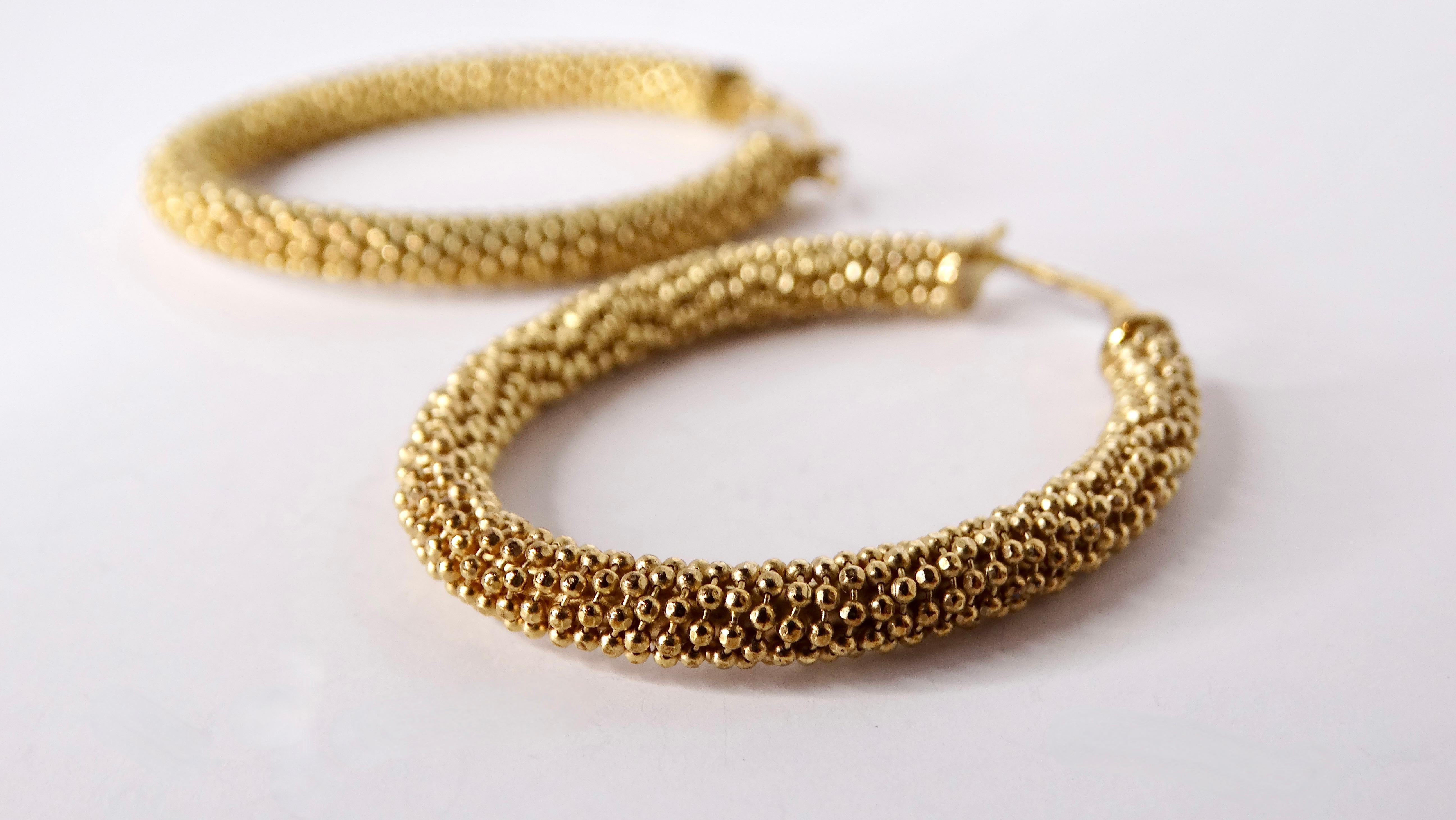 Questi squisiti orecchini a cerchio con perline in oro 18 carati, realizzati a mano negli anni '80, incarnano l'arte e l'eleganza della gioielleria vintage. Realizzati con un'attenzione meticolosa per i dettagli, le perle dorate riflettono una luce