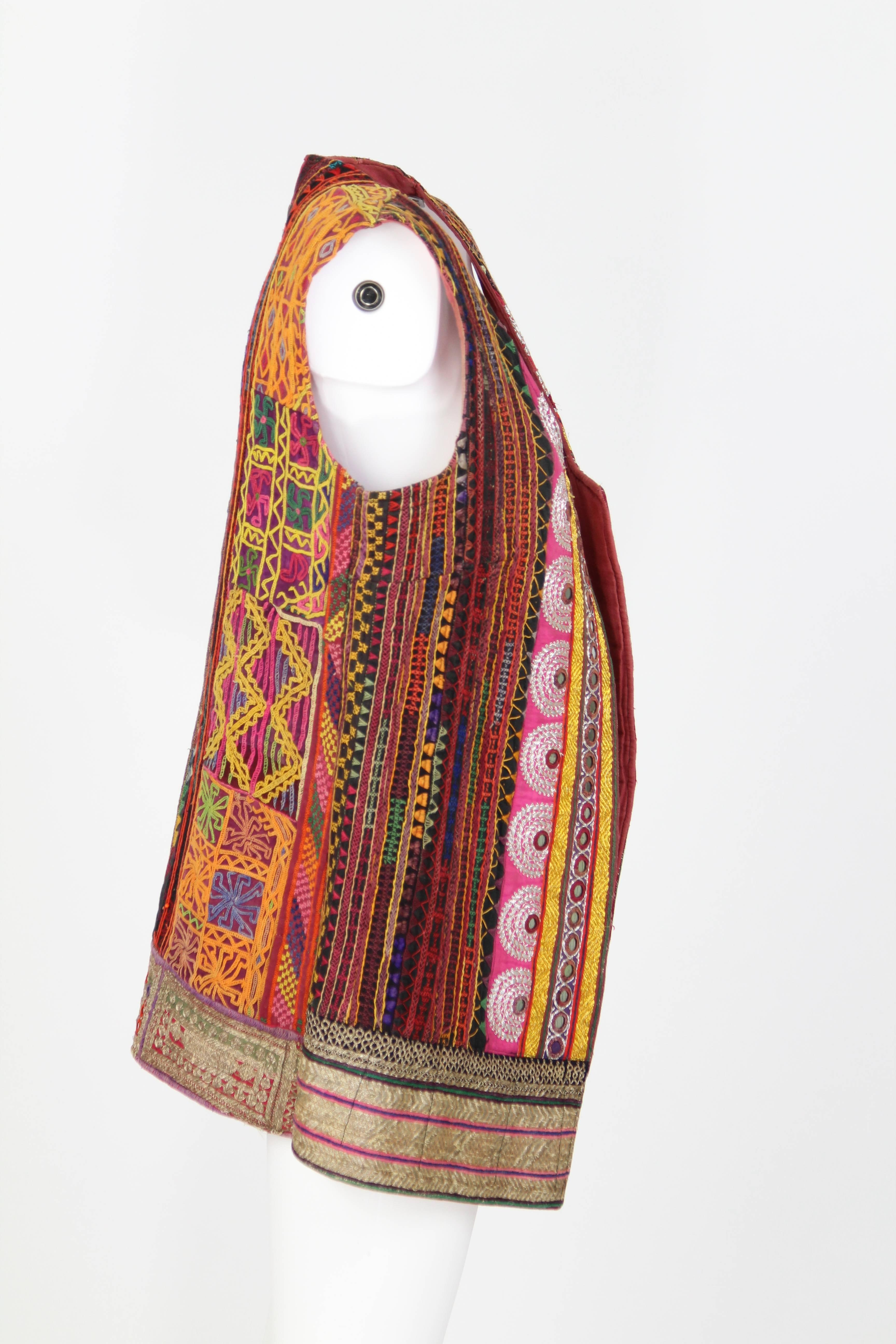 1980s Colorful Ethnic Gilet carfelly handmade and embroidered, made of original ethnic cloths from Rajasthan, a region of India. 
Small mirrors are sewn all over the item giving it a special allure.
The item presents signs of use but it is overall