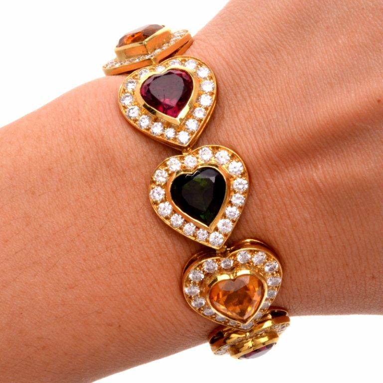 This beautiful 1980's bracelet displays a gorgeous heart shaped link design in solid 18K yellow. Centered with 10 genuine heart cut semi precious gems all GIA Certified (green tourmaline, pink tourmaline and yellow citrine, natural green quartz,