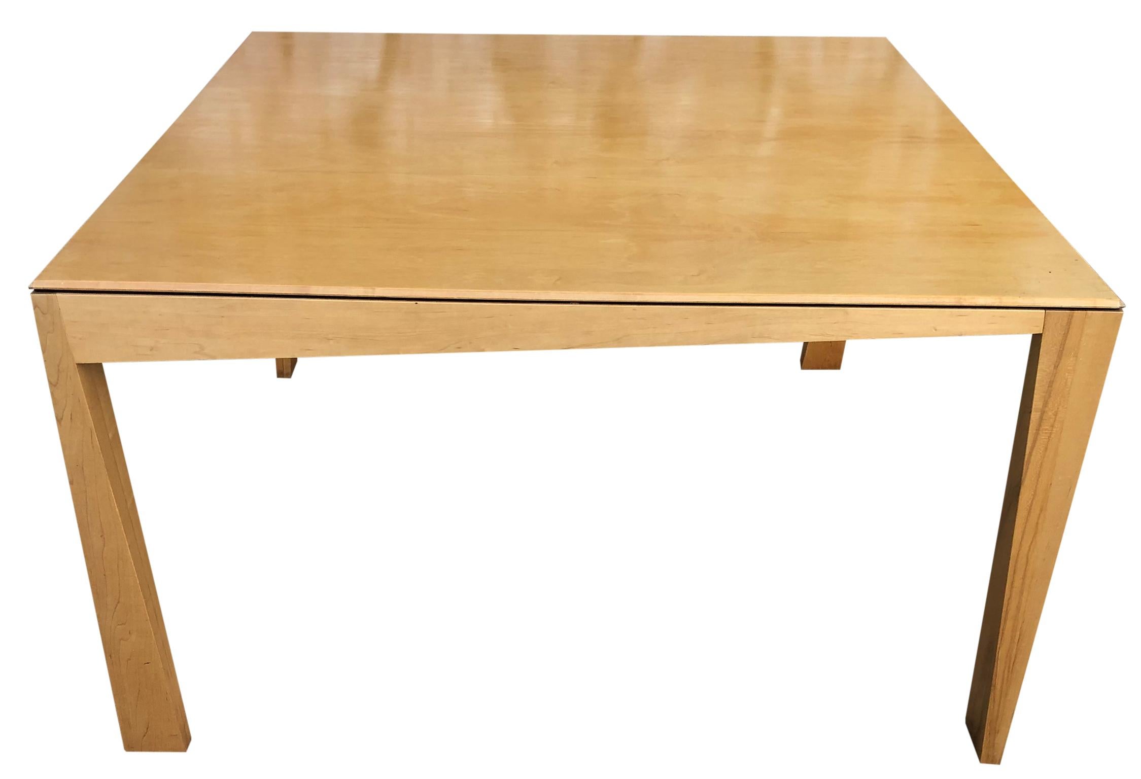 Beautiful 1980s Hennie de Jong square asymmetrical leg maple square dining table blonde maple finish, Sculptural design. Very delicate designed dining table with asymmetrical legs. Solid maple. You are buying (1) dining table. Fits up to 8 chairs.