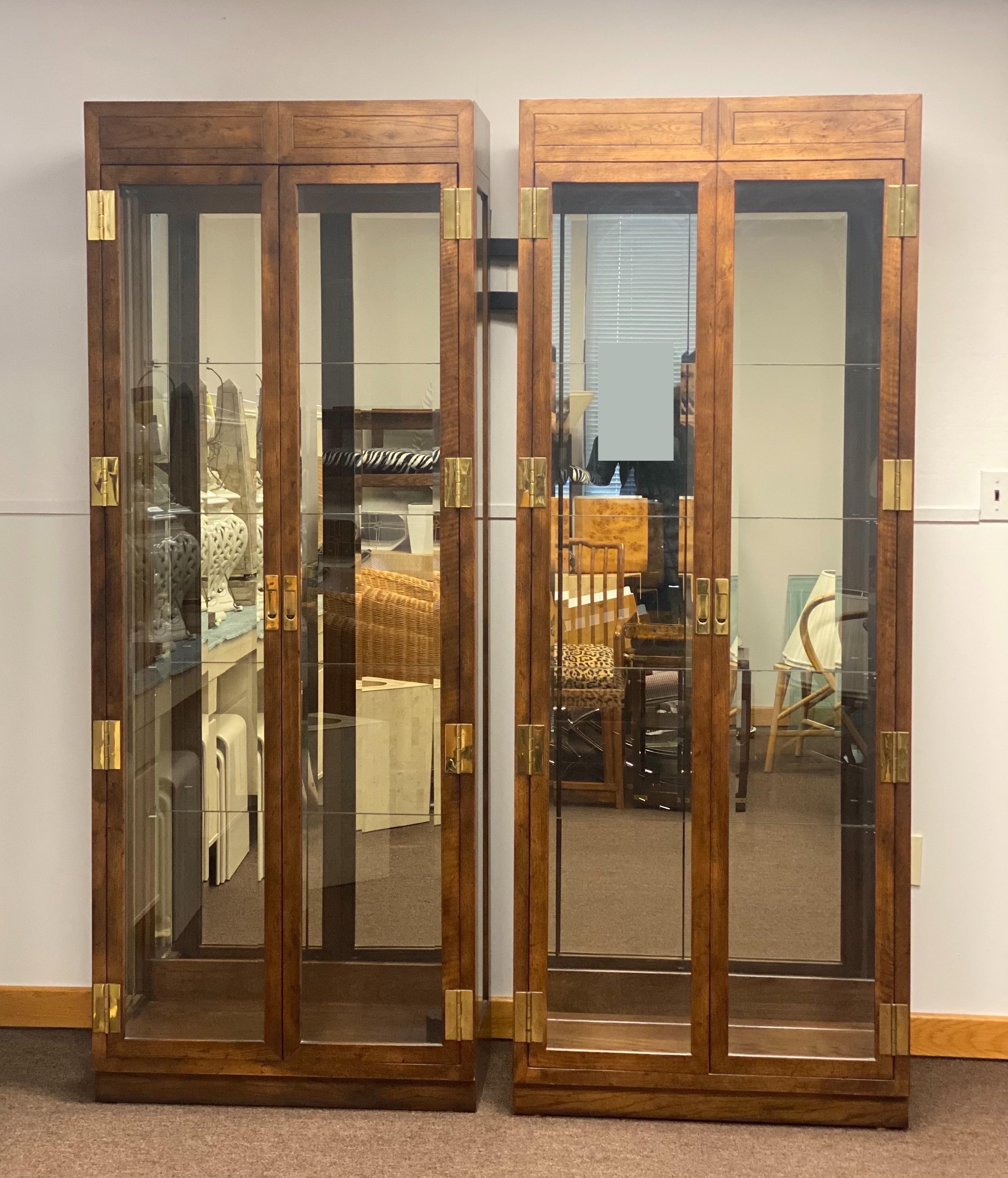 We are very pleased to offer a beautiful set of display cases from the Scene One Collection by Henredon, circa the 1980s. These traditional campaign style cases are showcase pieces by themselves, crafted from oakwood and ornamental solid brass