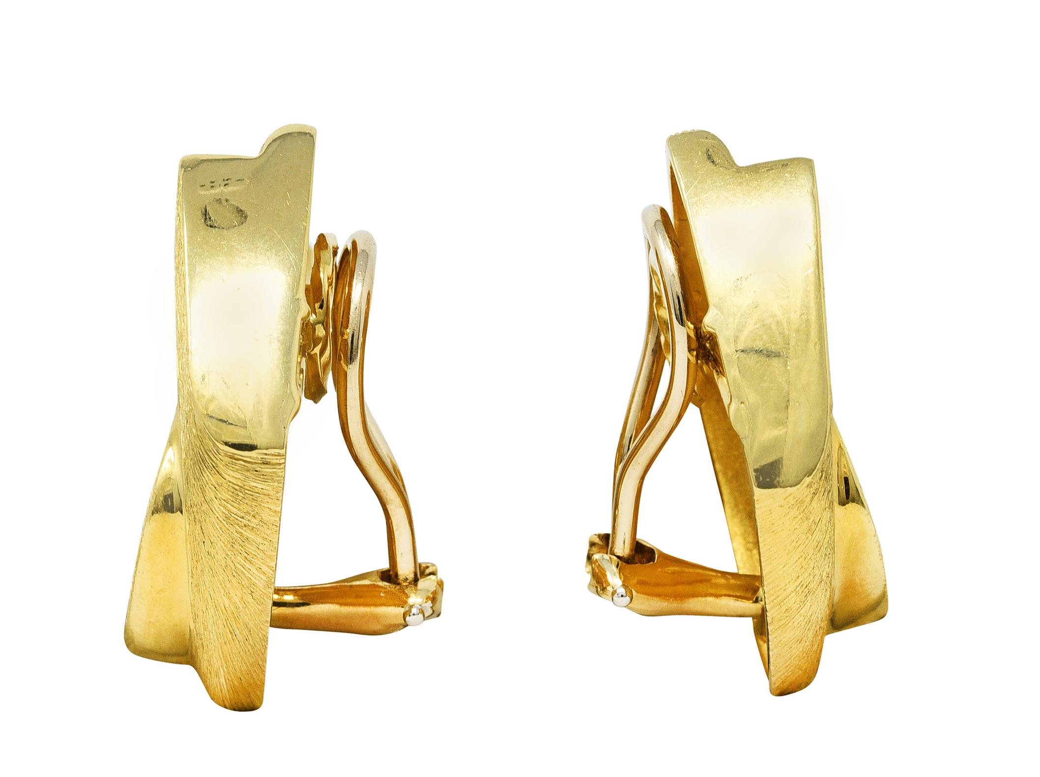 Ear clips are navette shaped with split curved interlocking motif

Accented by deeply brushed gold with high polished edges

Completed by hinged omega backs

Stamped 18k for 18 karat gold 

Numbered and signed for Henry Dunay

From the vintage Sabi