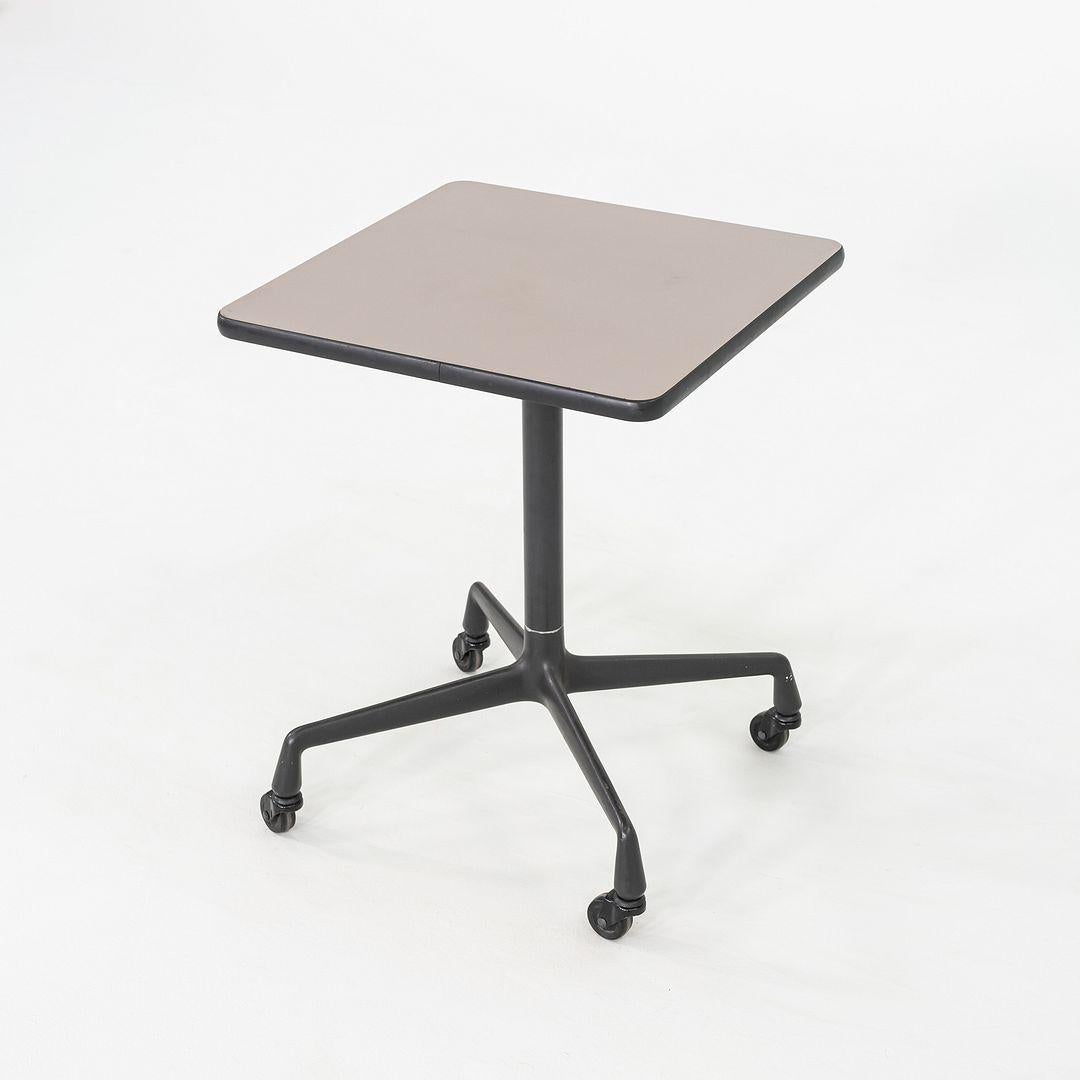 This is an Eames Rolling Side Table on a Universal Base, originally designed by Ray and Charles Eames in 1968. This particular example was produced by Herman Miller in the 1980s. The table's design is comprised of a sand casted aluminum base on