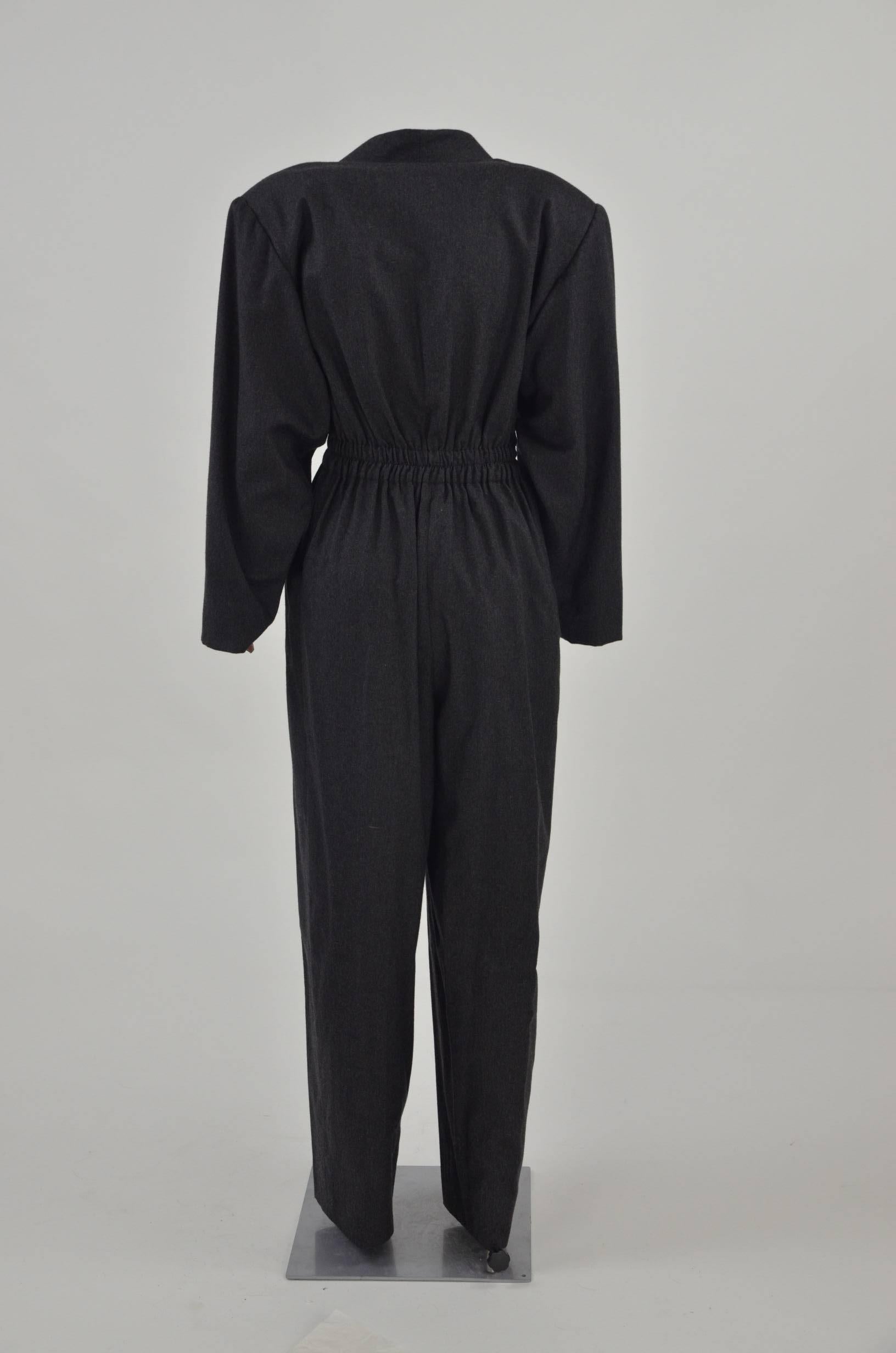 Grey wool and cashmere jumpsuit from Hermès with a wrap style front, a belted waist, long sleeves, a loose fit, a wide leg and side pockets. The jumpsuit is from the 80s.

Please note that this item has some minor defects, as the pictures show.