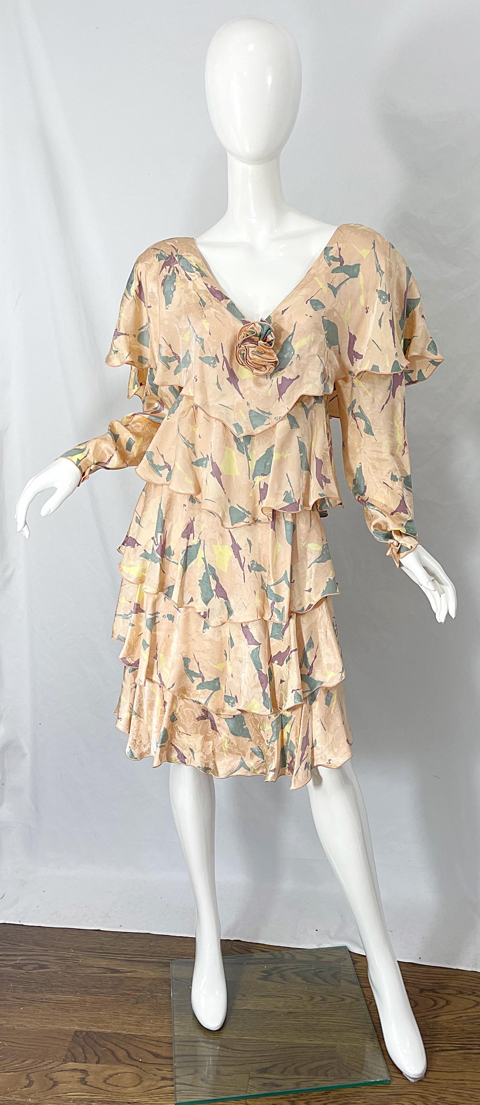 Beautiful early 80s HOLLY’S HARP peach tiered long sleeve silk dress ! Signature Harp style with shoulder pads and rosette at center bust. Sleeve cuffs have button closure. Wonderful warm colors of green, yellow and purple abstracts throughout.