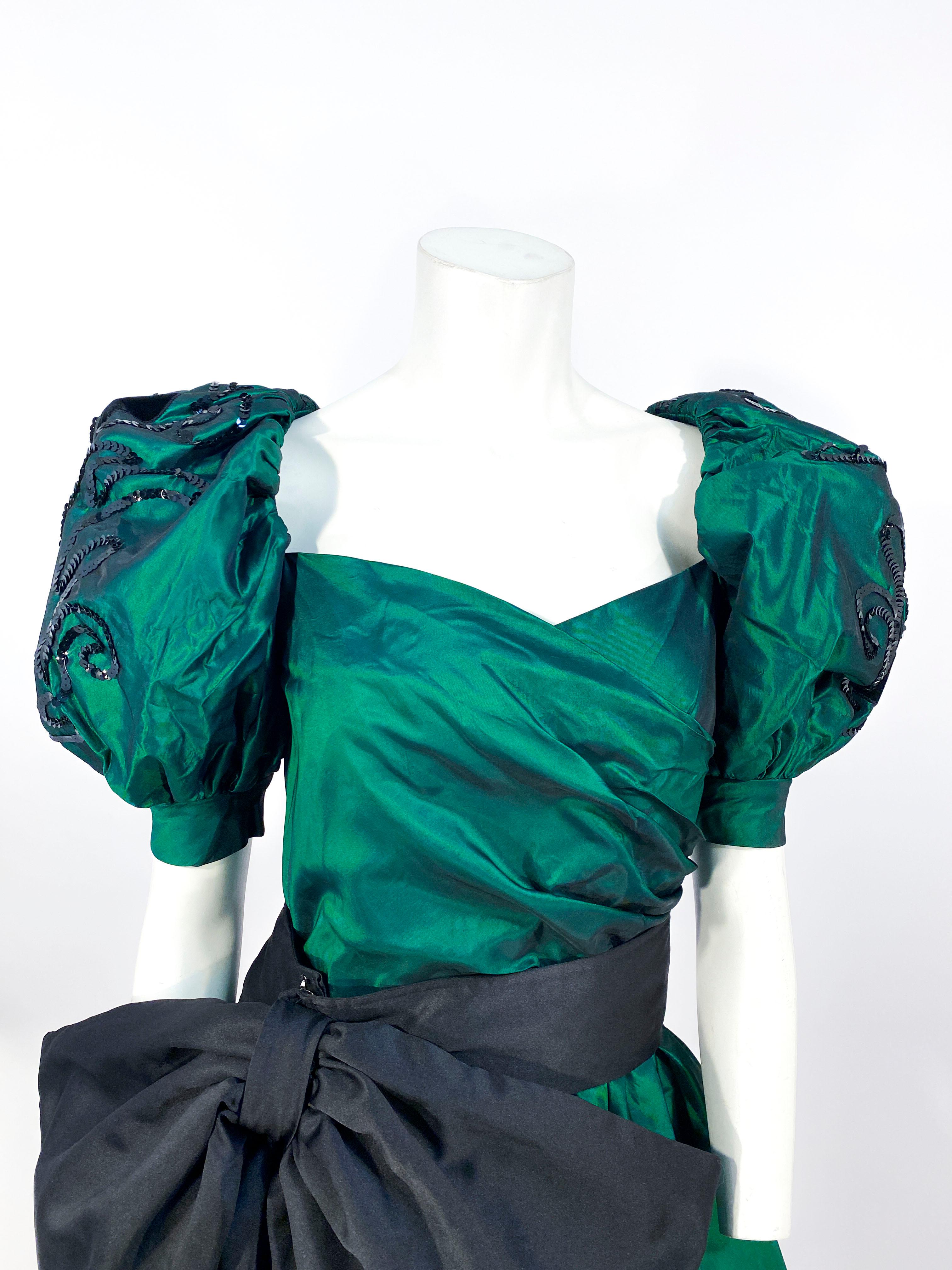 1980's Huey Waltzer dress with oversized puff sleeves, sequin and velvet appliqué accents, ruching along the bodice, and a full ballon skirt lined in taffeta for structure. This piece also has a removable enlarged black bow cummerbund worn on the