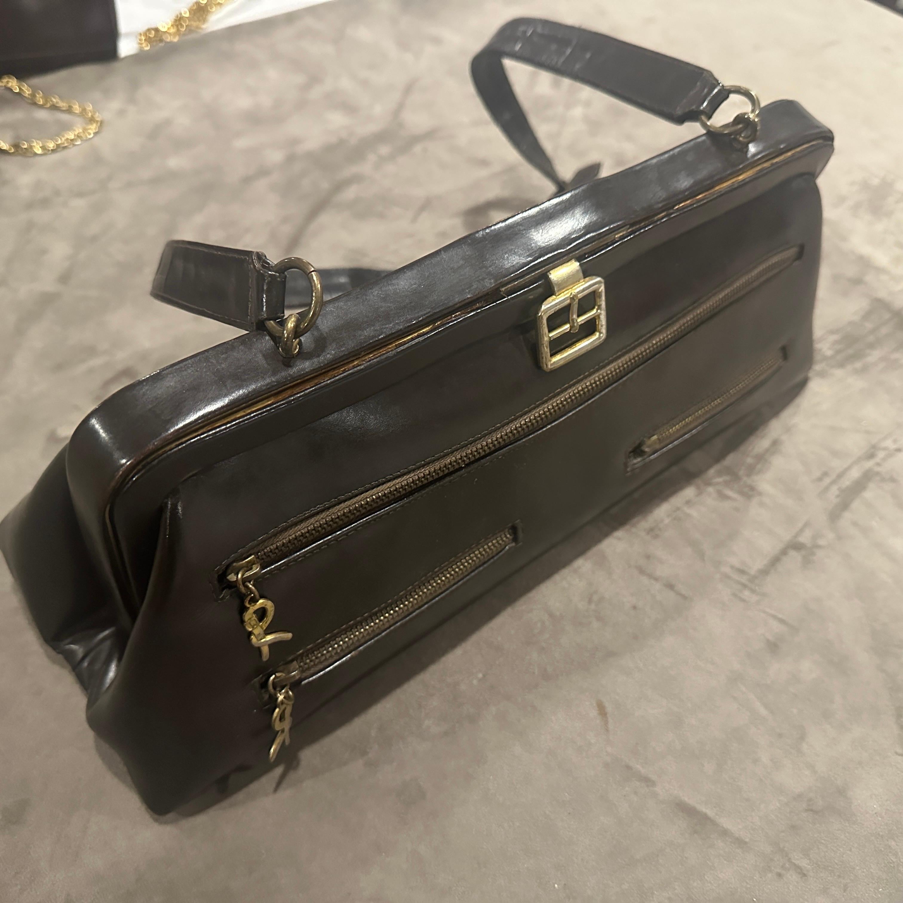 Immergiti nell'eredità del lusso veneziano con questa sofisticata borsa a mano anni '80 di Roberta Di Camerino, un pezzo che bilancia perfettamente il rigore architettonico del marchio con l'eleganza italiana senza tempo. Realizzata in pelle liscia