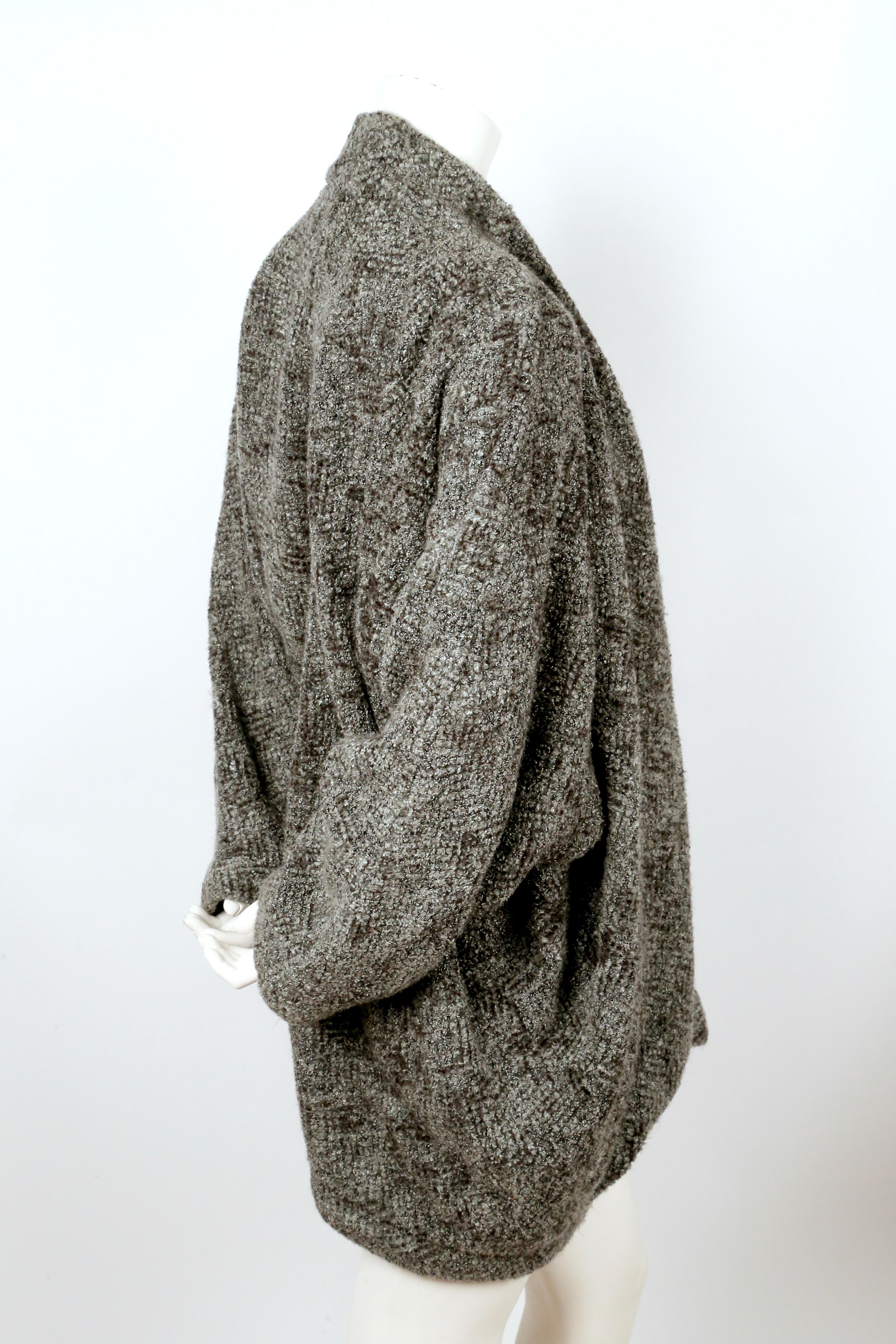 Grey boucle knit, cocoon style sweater coat designed by Issey Miyake dating to the 1980's. No size is indicated however this will fit many sizes to to the oversized cut. Unlined. Pockets at hips. Good condition. 