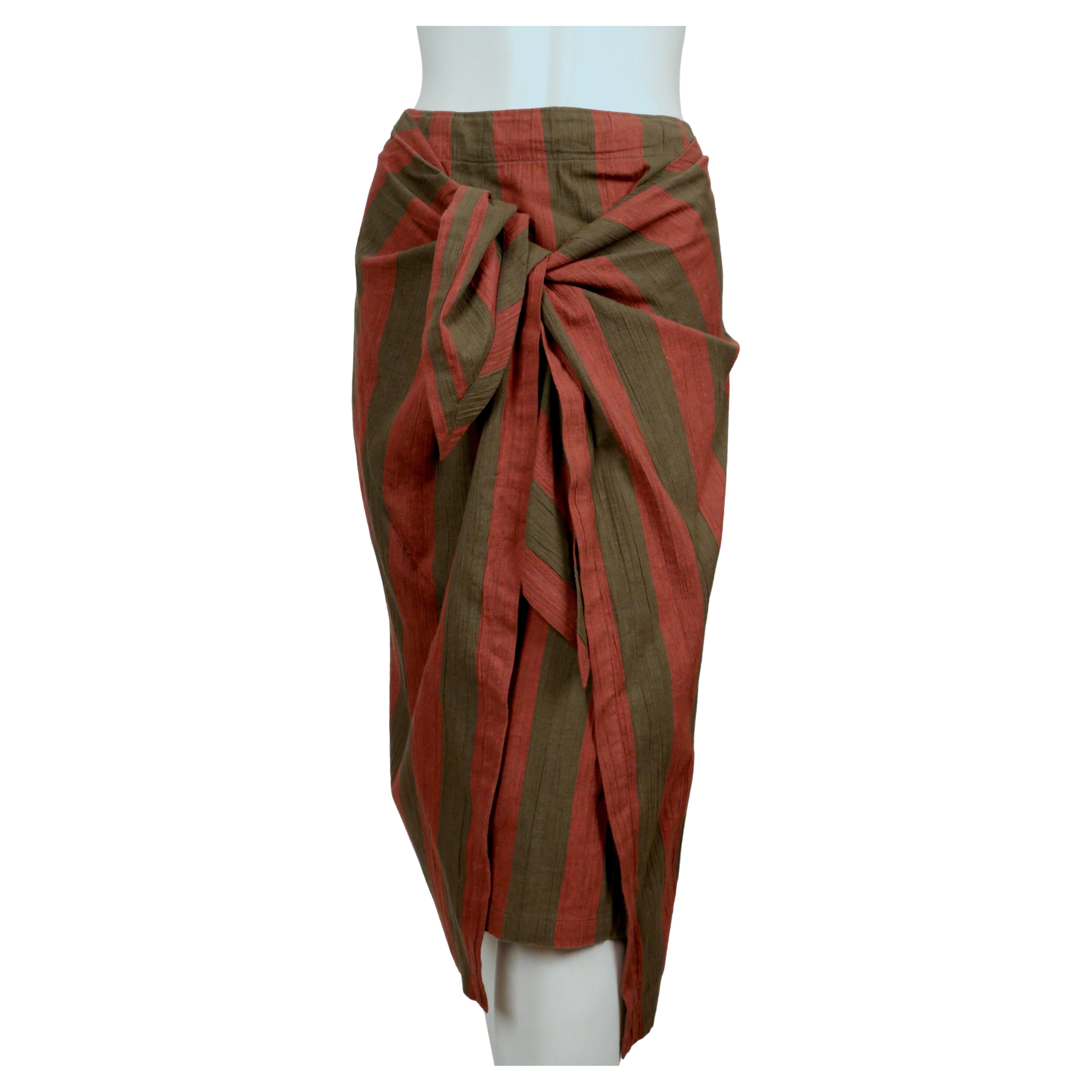 Khaki and terracotta striped skirt with draped closure designed by Issey Miyake dating to the early 1980's.  Labeled a Japanese size '9'.  The skirt measures approximately 28