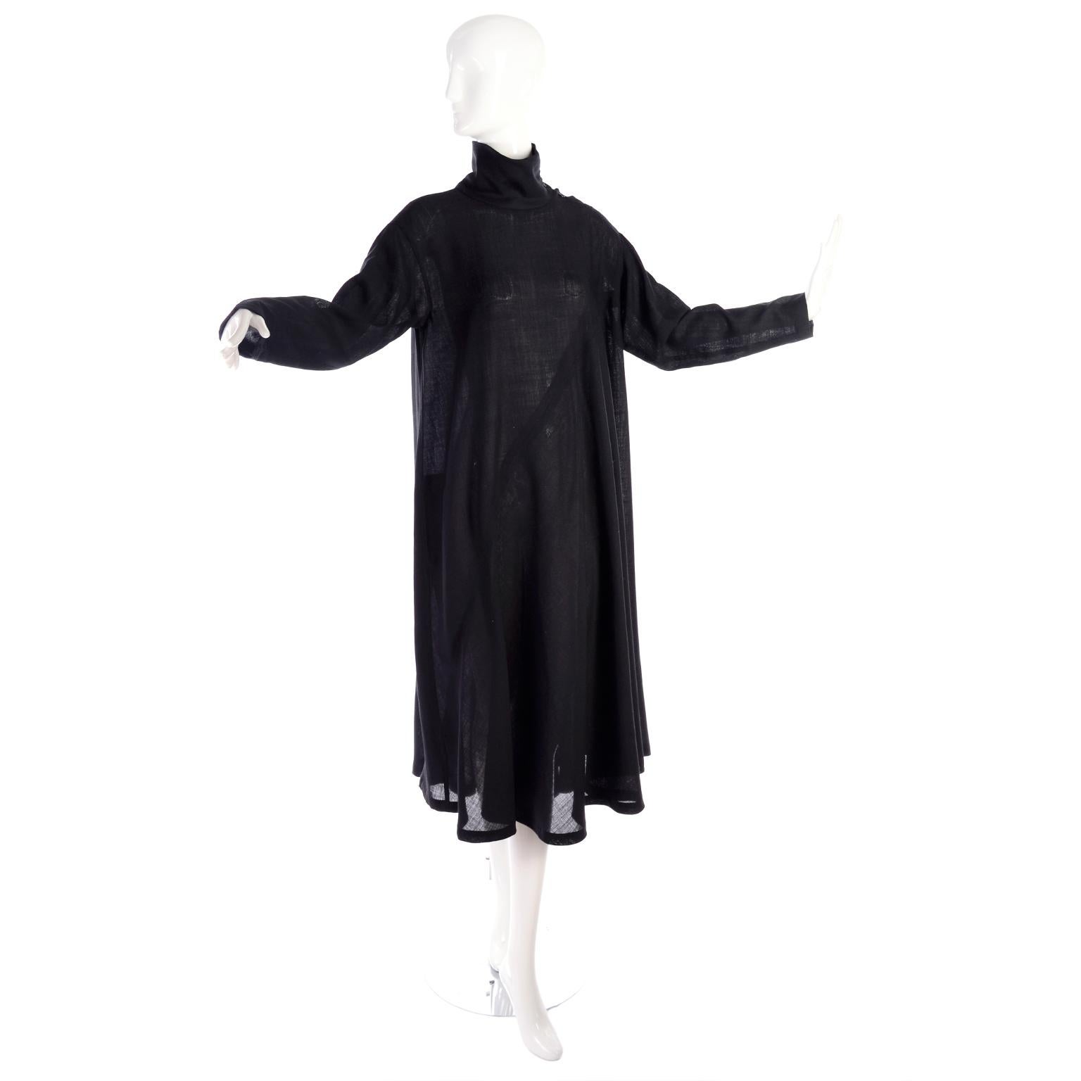 This is a truly iconic vintage 1980's Issey Miyake tent mock turtleneck dress in his signature style in a lightweight black wool crepe. The dress has long sleeves and buttons at the neck. Labeled a size small, the dress has a versatile fit because