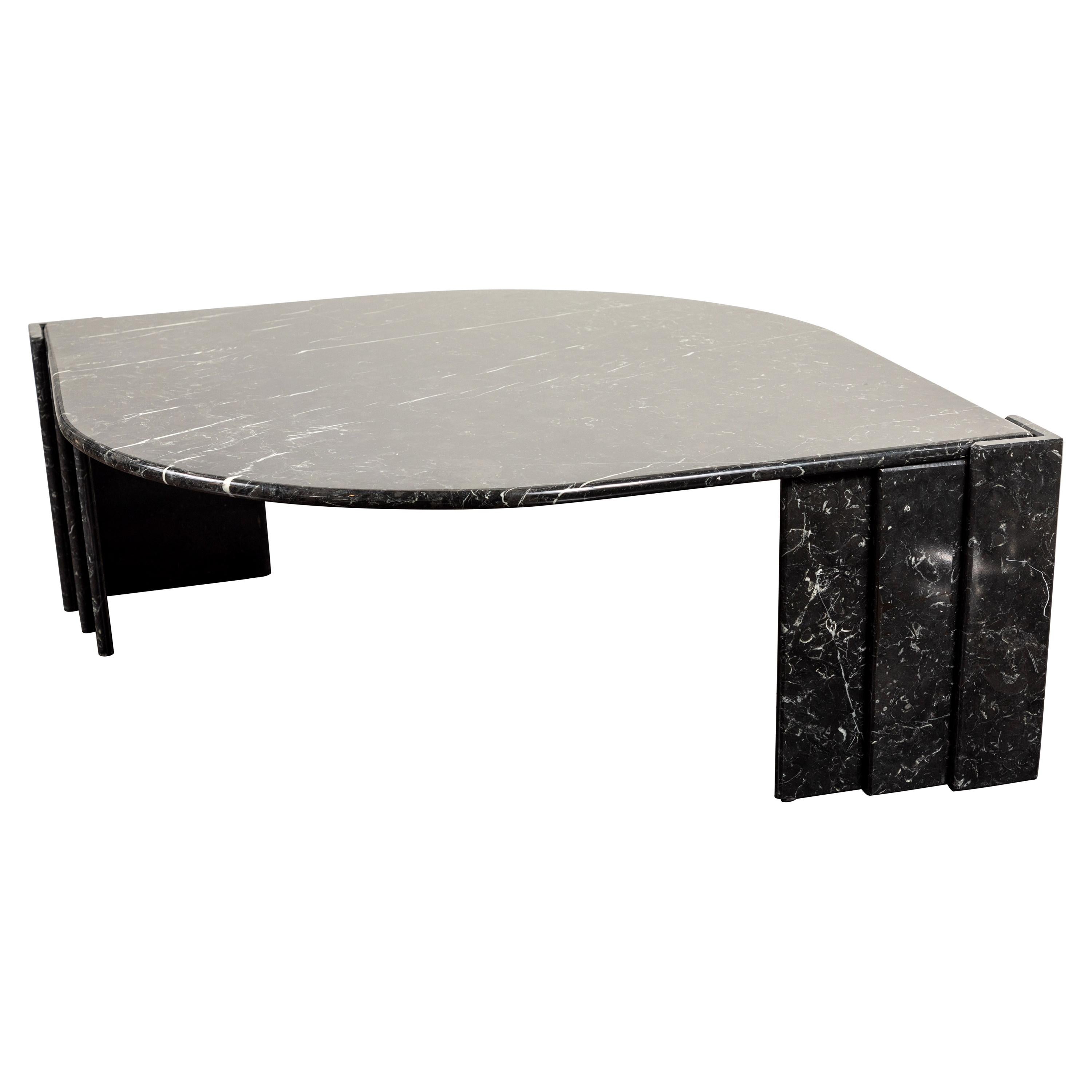 Sophisticated Italian black marble coffee table, 1980s. The top of the table is teardrop-shaped and is supported by two faceted plinth bases on either end. The marble displays subtle white veining throughout. Excellent condition.