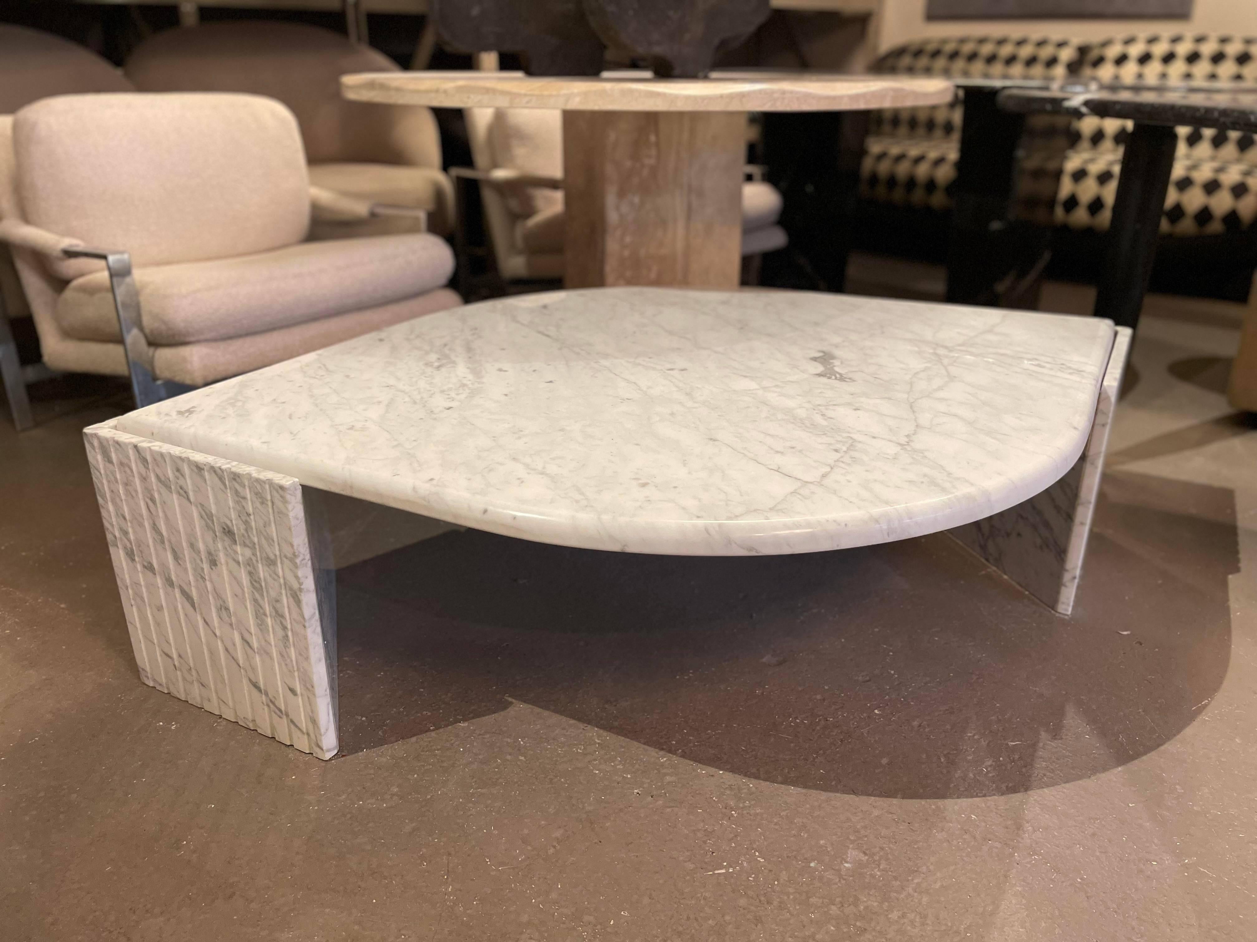 Breathtaking postmodern Carrara Marble coffee table with triangle channeled bases. Very sturdy and in excellent condition. The top perfectly floats on the bases. Made in Italy.

Dimensions: 63