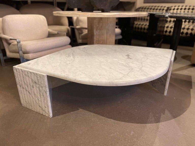 Breathtaking postmodern Carrara Marble coffee table with triangle channeled bases. Very sturdy and in excellent condition. The top perfectly floats on the bases. Made in Italy.

Dimensions: 63