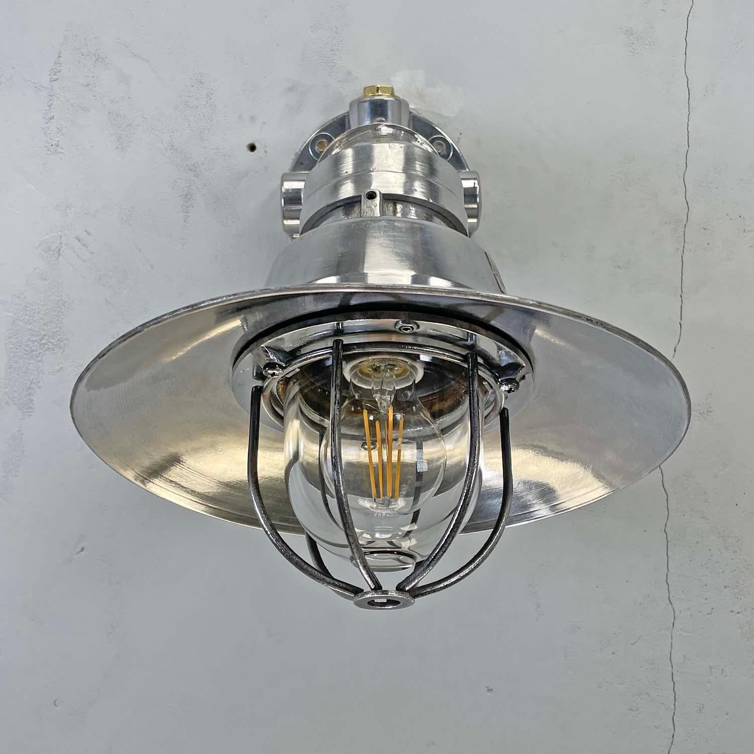 Vintage industrial cast aluminium cantilever wall lighting with tempered glass dome, cage and aluminum shade. Add a touch of the industrial to your interior with these large metal wall light fixtures. Reclaimed from Cargo ships and super tankers