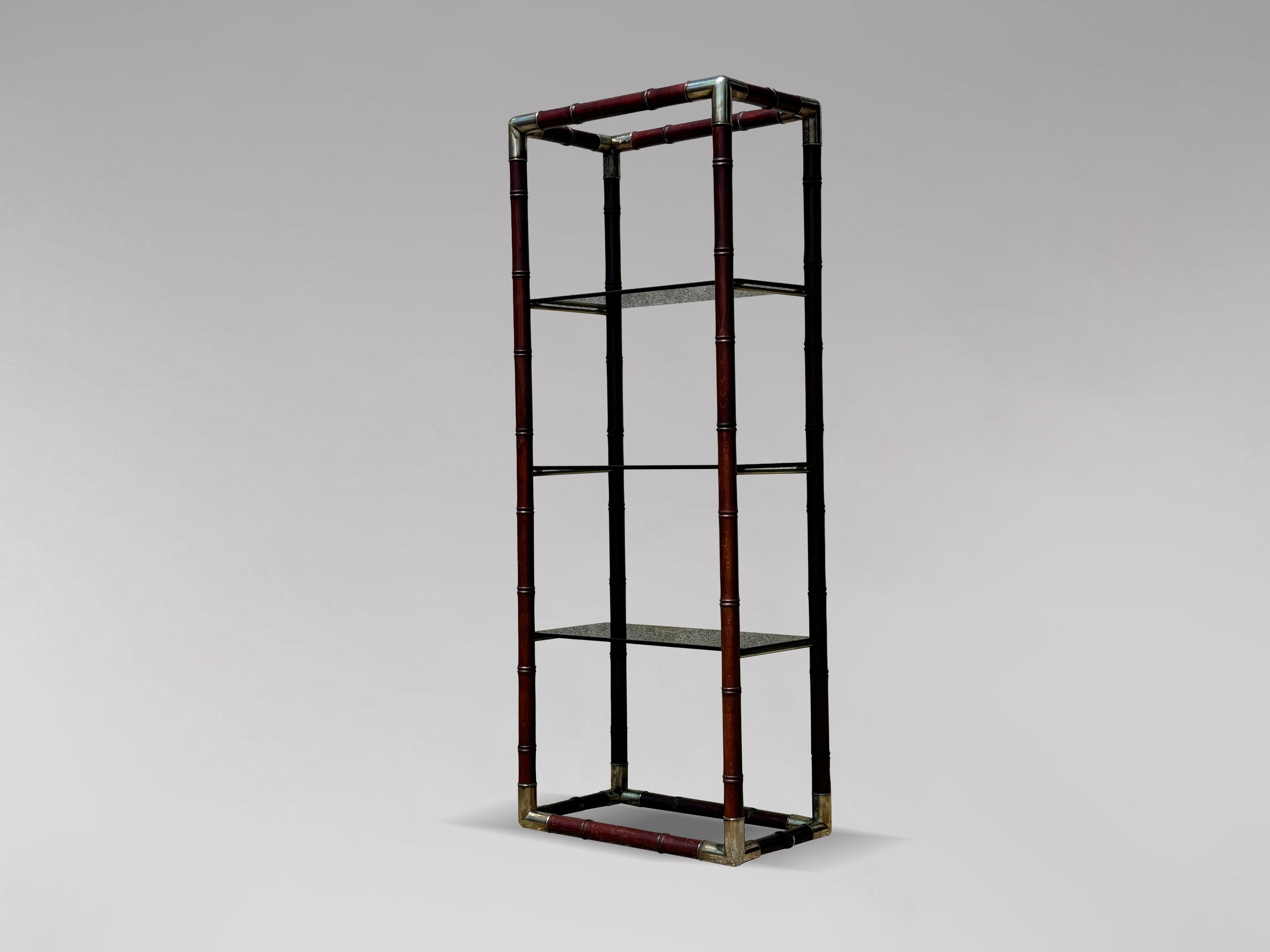 A late 20th-century, 1980s Italian faux bamboo mahogany frame structure, three-tier shelving unit, bookcase, or display étagère with brass-detailed connections at the corners. It comprises three smoked glass shelves. A stable and solid structure
