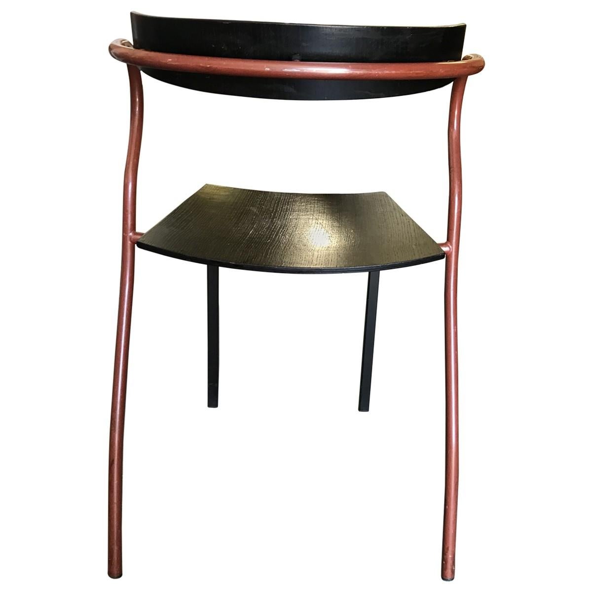 Ebonized wood curved backrest and trapezoid black seat.
Brick red simulated stone-finish metal curved unusual armrest and rear legs extending outward.
Black square iron front legs are attached to the seat as the back legs are attached to the