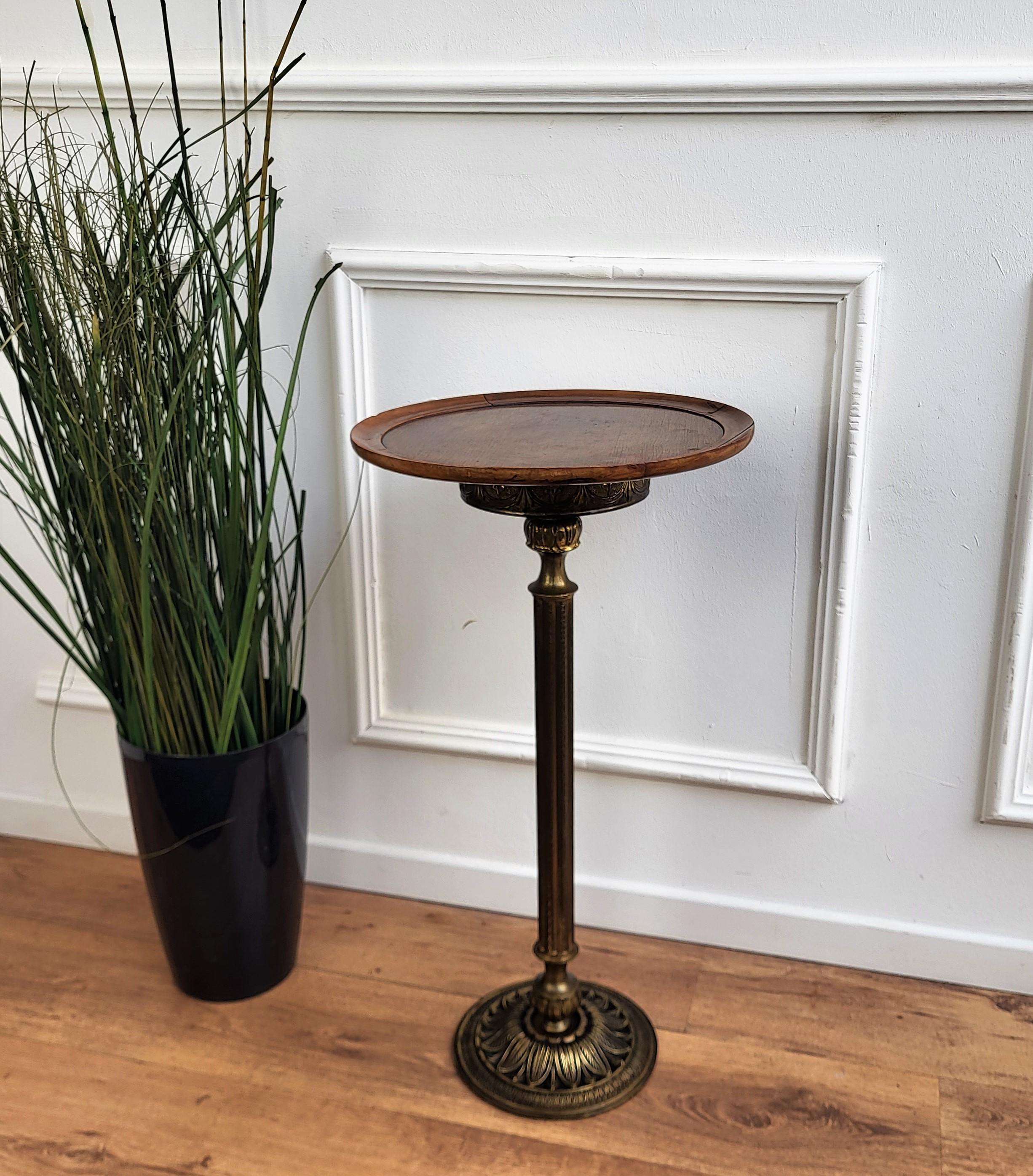 Beautiful and stylish vintage 1980s Italian brass side table or pedestal table stand. Very good condition with great brass metal part fully decorated with classical motifs and roud wooden top.
 