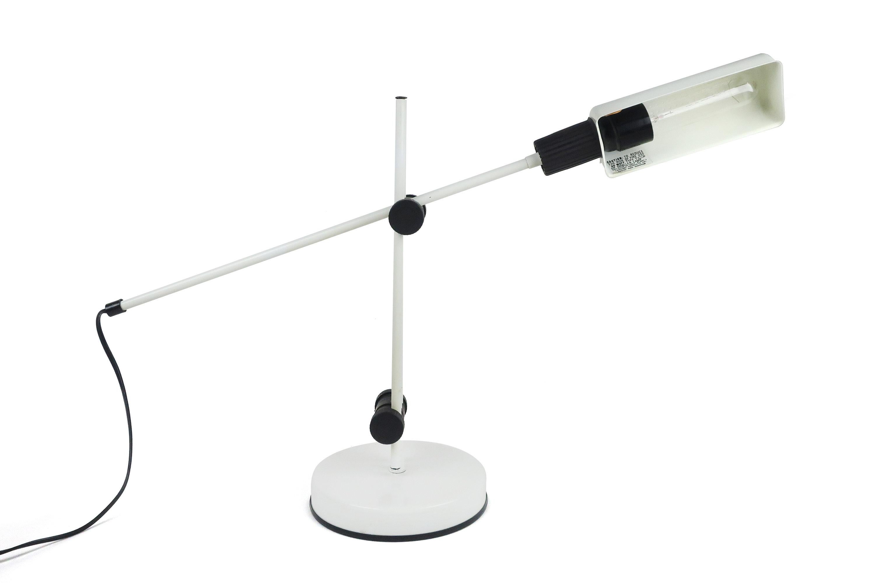A minimalist 1980s Italian modern adjustable Veneta Lumi table lamp that pivots in two places and features a rotating shade. White shade, stem, and heavy base, the lamp has black contrasting accents.
 
 In great vintage condition and works