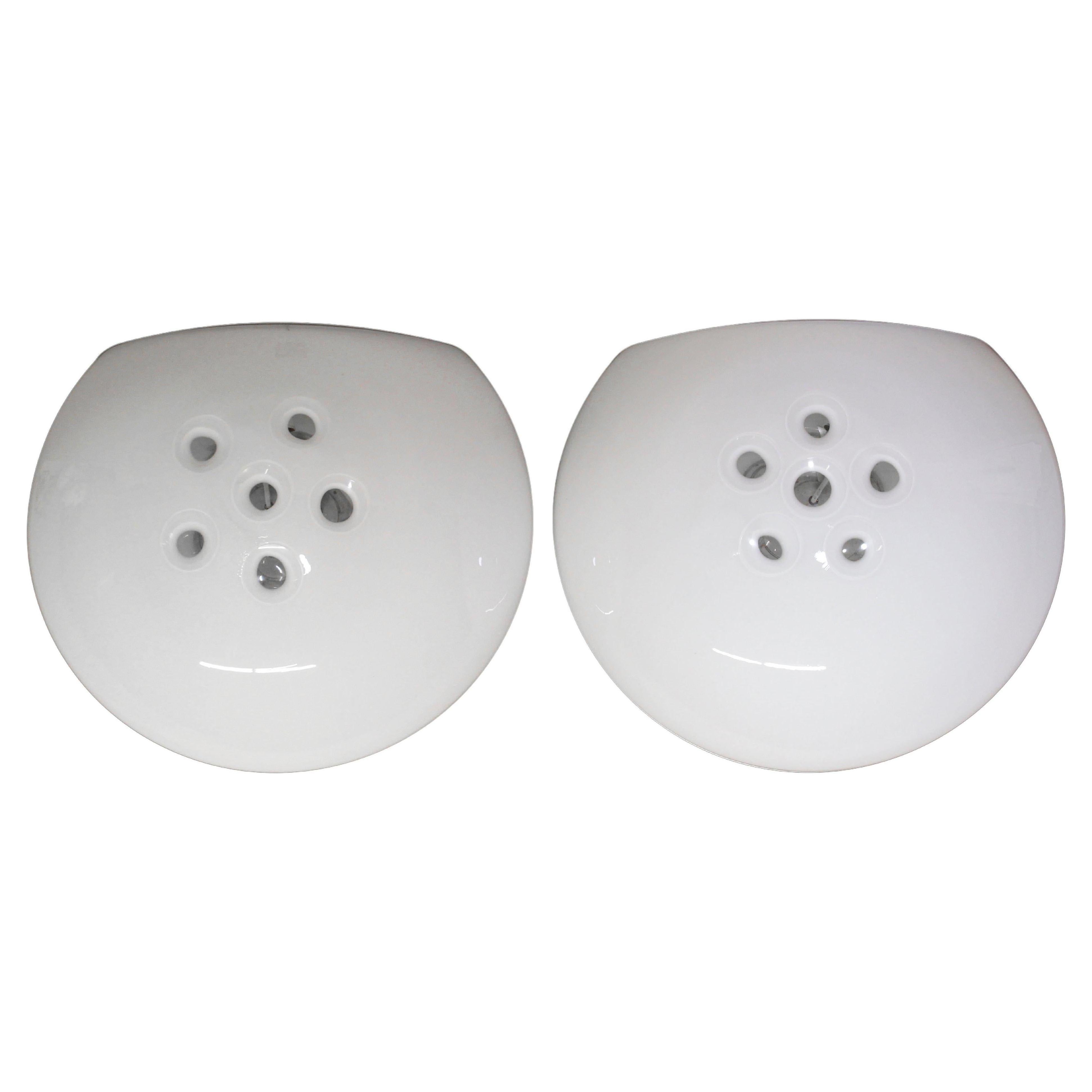 Queste applique di Murano hanno una forma rotonda unica, con la parte superiore aperta e sei fori al centro per fornire luce. Risalgono agli anni '80 e sono di colore bianco. Pulito e ricablato. Prezzo a coppia. Si prega di notare che questo