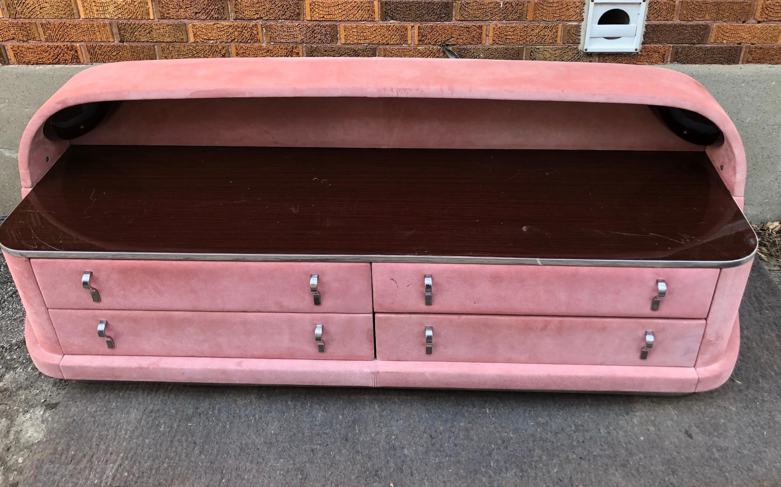 Outrageous 1980s Italian four-drawer dresser with canopy, and recessed lights, unusual pink suede wrapped with rosewood laminate top and drawer interiors, detailed with chrome drawer pulls and chrome base, make a statement in any room. Hand delivery