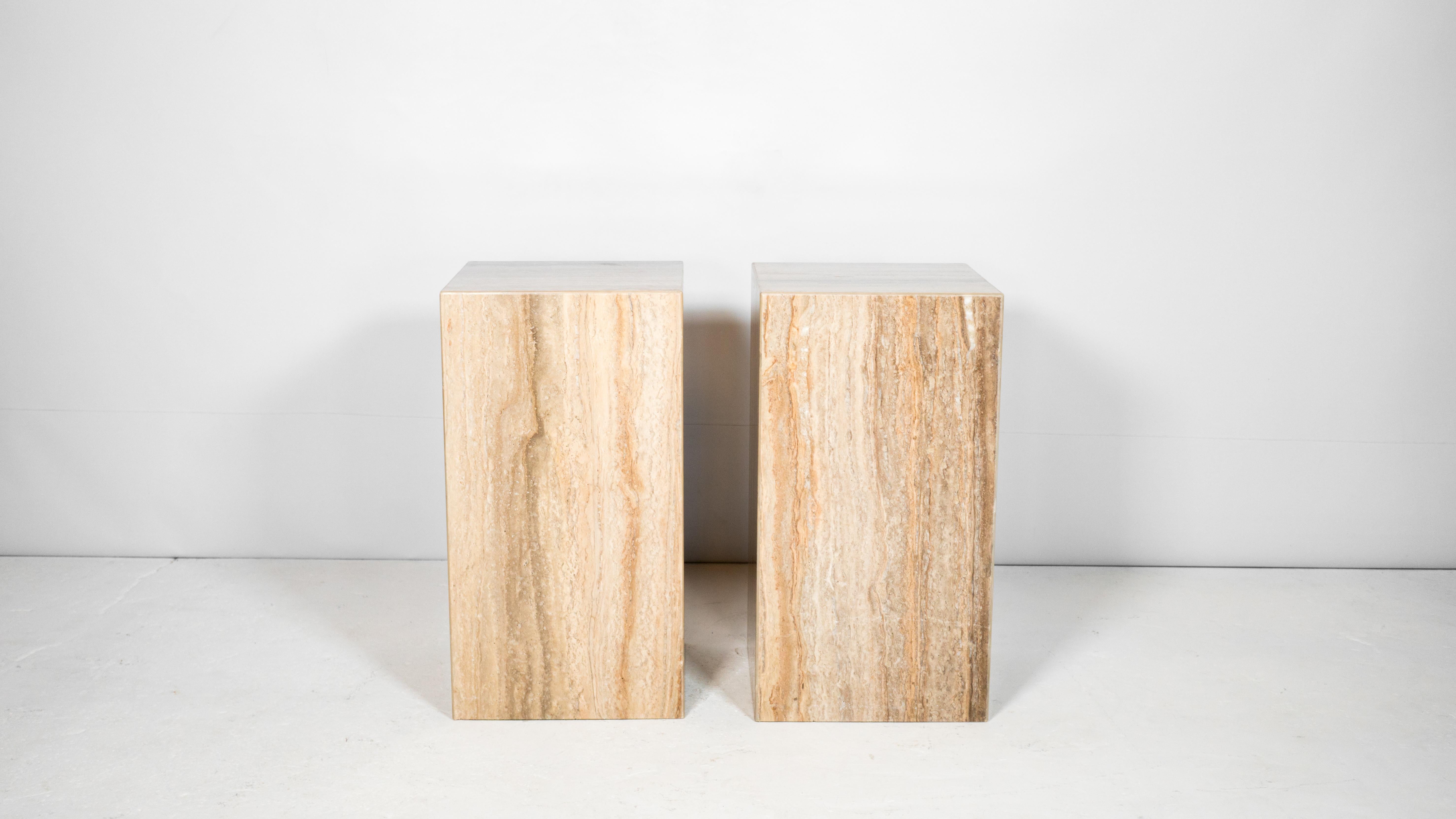 Impressive pair of large Italian travertine side tables, circa 1980s. Beautiful grain seen throughout the polished stone with vibrant neutral earth tones and hues. Presence offer elegance while maintaining minimalist design. Rectangle cuboid shape